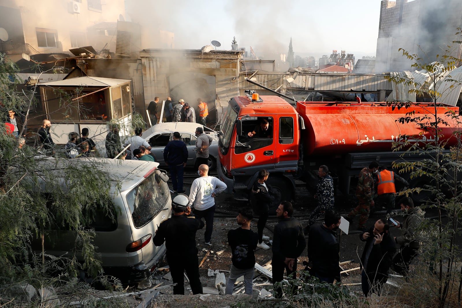 Firefighters and security officers gather at a destroyed building hit in an Israeli airstrike in Damascus, Syria, Thursday, Nov. 14, 2024. (AP Photo/Omar Sanadiki)