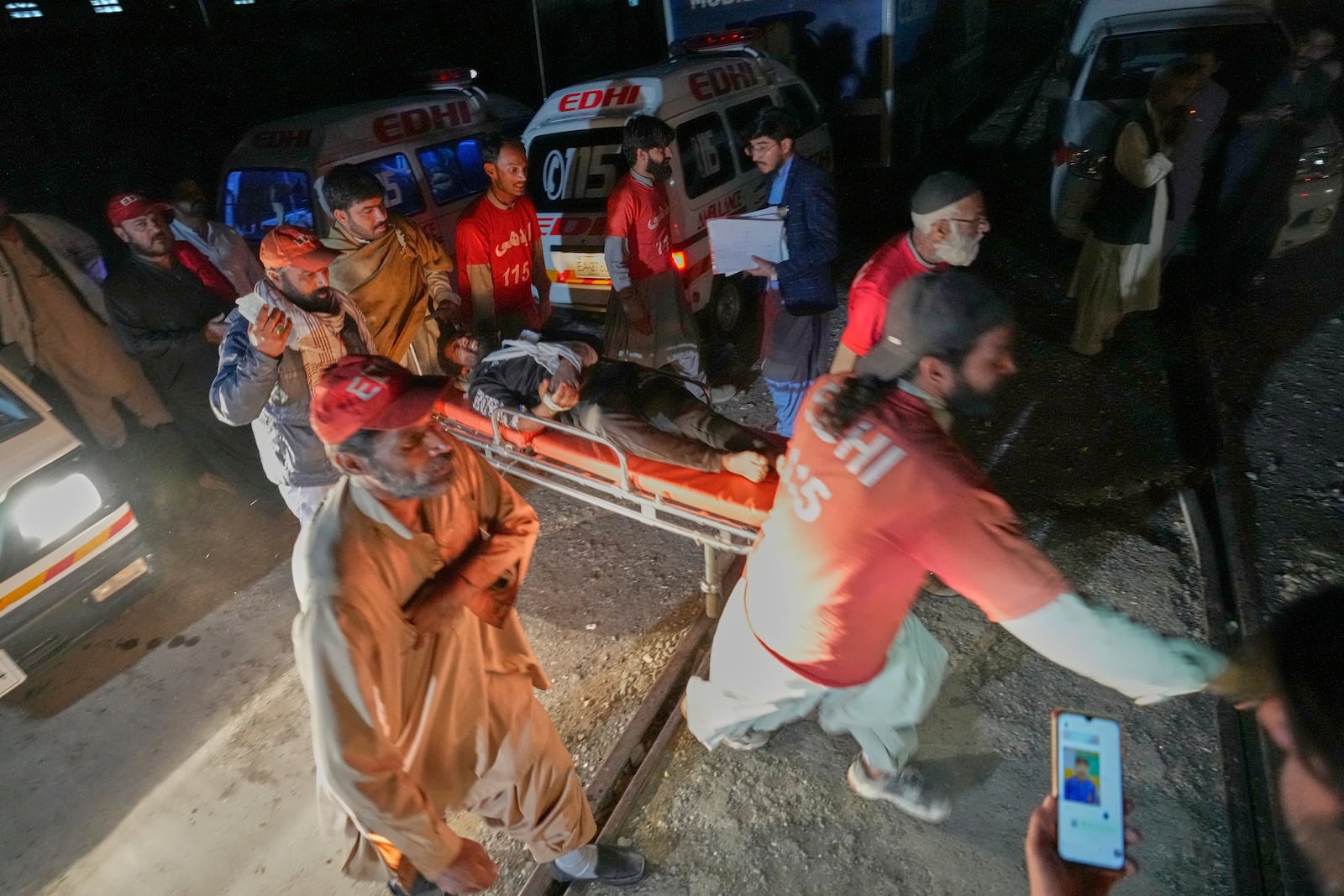 An injured passenger, rescued by security forces from a passenger train attacked by insurgents, is carried on a stretcher after arriving on a special train for the wounded and survivors, organized by the army, at a railway station in Much, in Pakistan's southwestern Balochistan province, Wednesday, March 12, 2025. (AP Photo/Anjum Naveed)