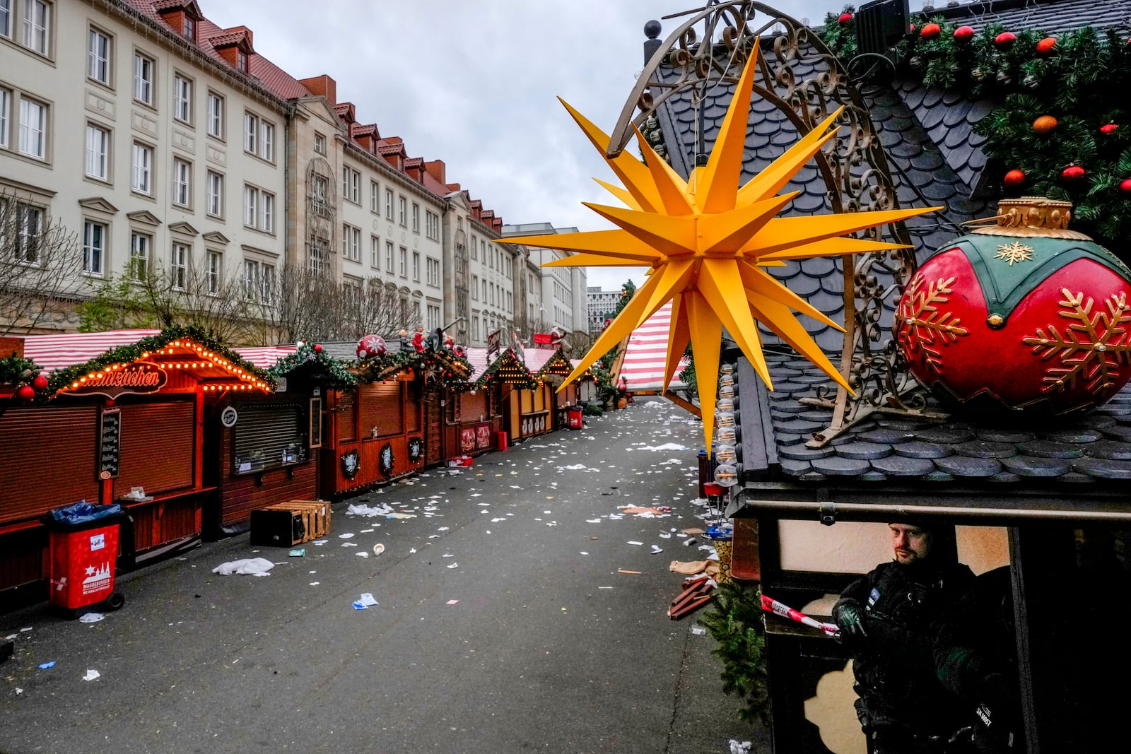 A policeman, right, stands on a Christmas Market, where a car drove into a crowd on Friday evening, in Magdeburg, Germany, Saturday, Dec. 21, 2024. (AP Photo/Michael Probst)