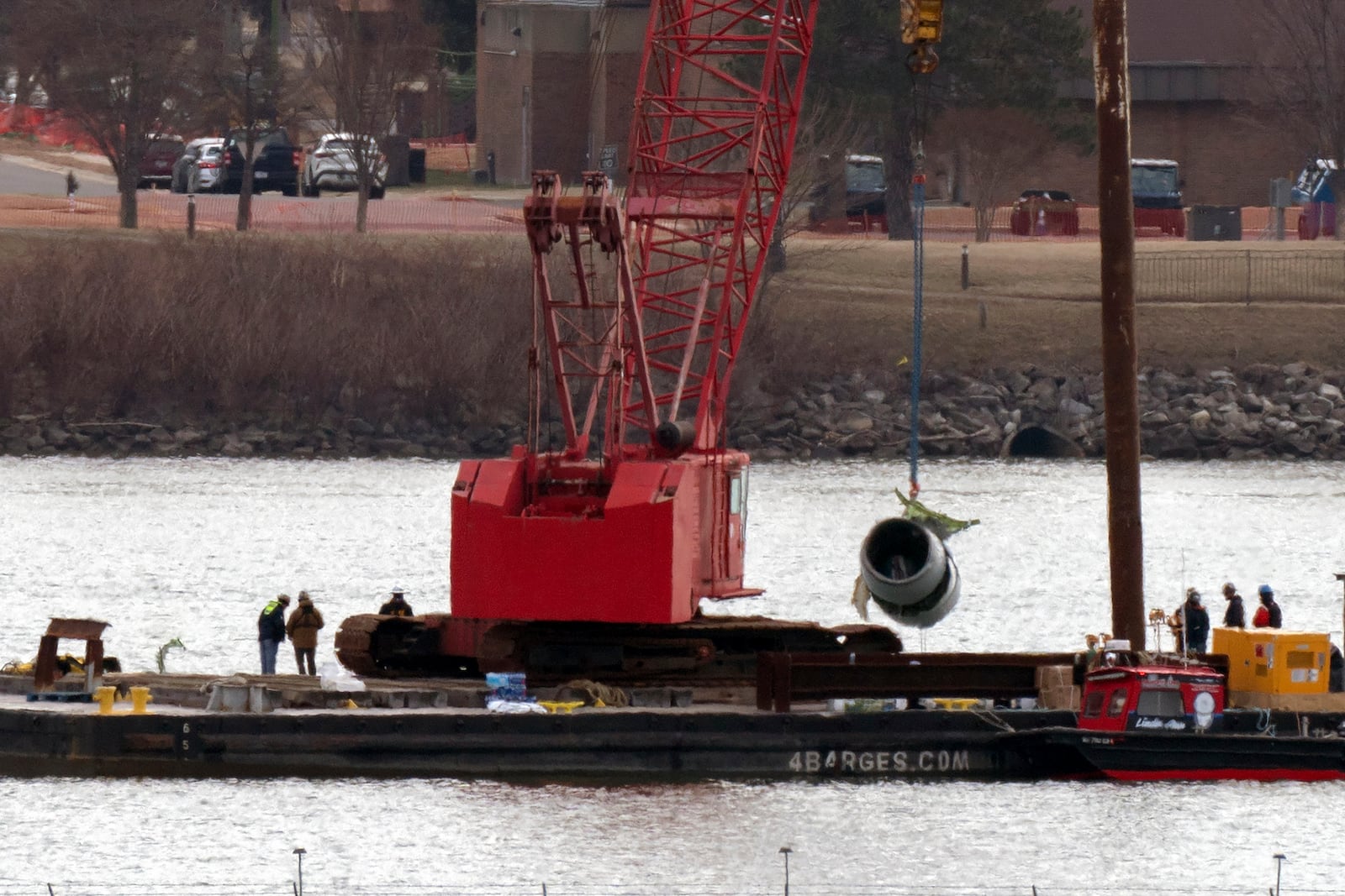 Rescue and salvage crews pull up a plane engine as cranes work near the wreckage of an American Airlines jet in the Potomac river from Ronald Reagan Washington National Airport, Monday, Feb. 3, 2025, in Arlington, Va. (AP Photo/Jose Luis Magana)