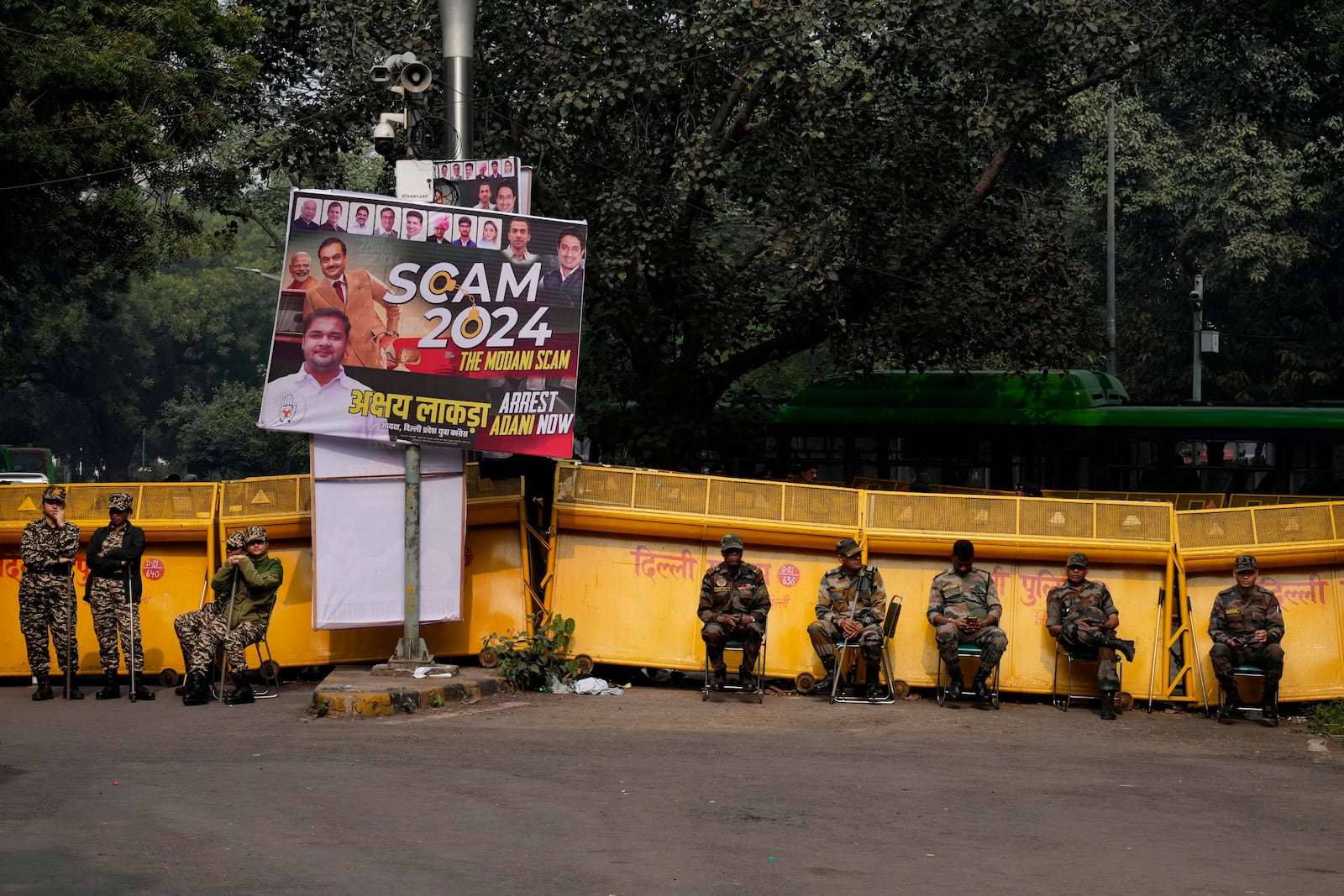 Security officials stand during a protest against Indian billionaire Gautam Adani and Indian Prime Minister Narendra Modi, after Adani was indicted by U.S. prosecutors for bribery and fraud, in New Delhi, India, Monday, Nov. 25, 2024. (AP Photo/Manish Swarup)