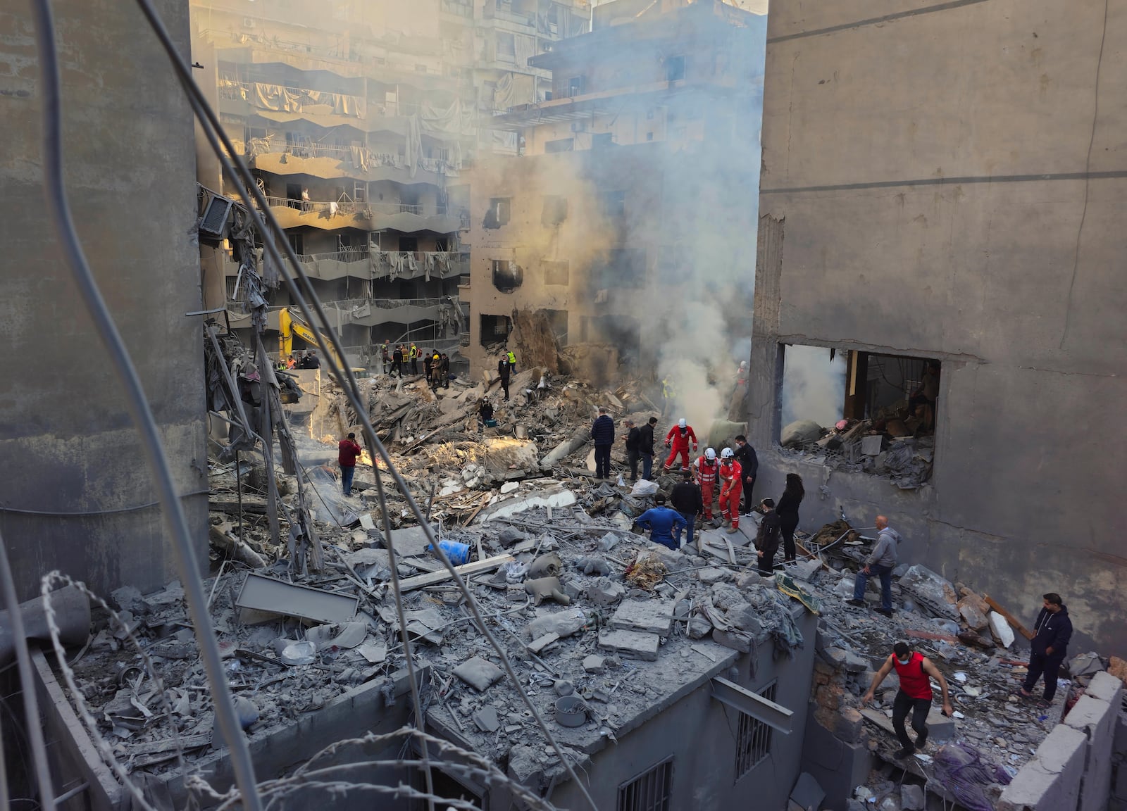 Rescue workers and people search for victims at the site of an Israeli airstrike that hit central Beirut, Lebanon, Saturday, Nov. 23, 2024. (AP Photo/Hassan Ammar)