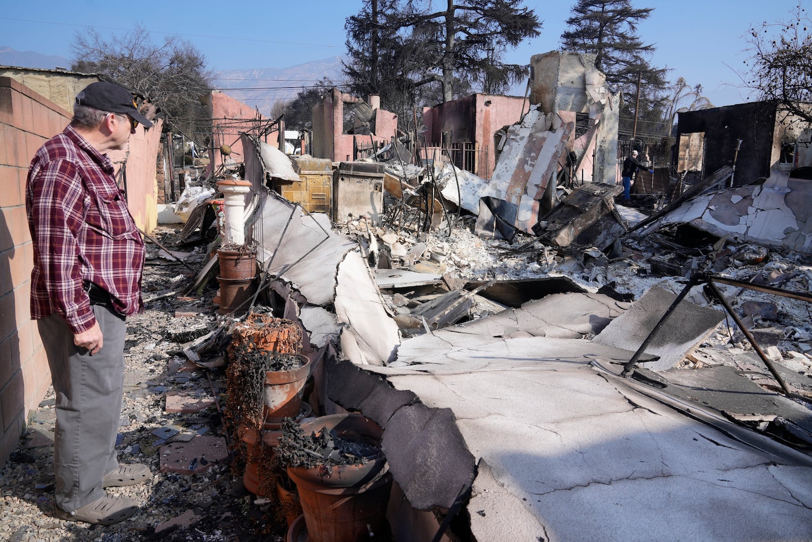 Joel Parkes, a teacher with the Los Angeles Unified School District returns to his destroyed home in the aftermath of the Eaton Fire, Sunday, Jan. 19, 2025, in Altadena, Calif. (AP Photo/Damian Dovarganes)