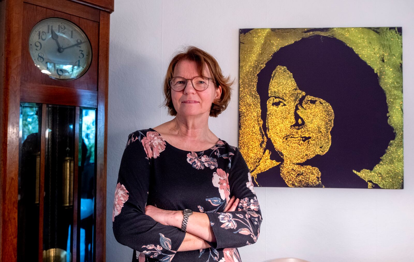 Claudia Huth poses next to a painting showing herself and painted by her son in her house in Egelsbach, Germany, Thursday, Oct. 31, 2024. (AP Photo/Michael Probst)