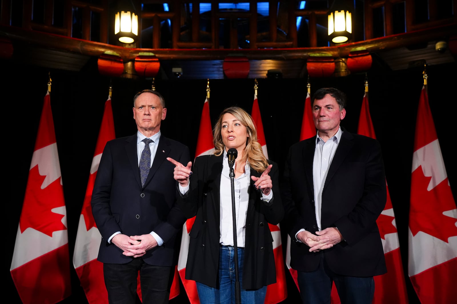 Canada's Minister of Foreign Affairs Melanie Joly is flanked by Minister of Public Safety David McGuinty, left, and Minister of Finance and Intergovernmental Affairs Dominic LeBlanc as they speak to reporters prior to a meeting during a cabinet retreat at Chateau Montebello in Montebello, Quebec, Monday, Jan. 20, 2025. (Sean Kilpatrick/The Canadian Press via AP)