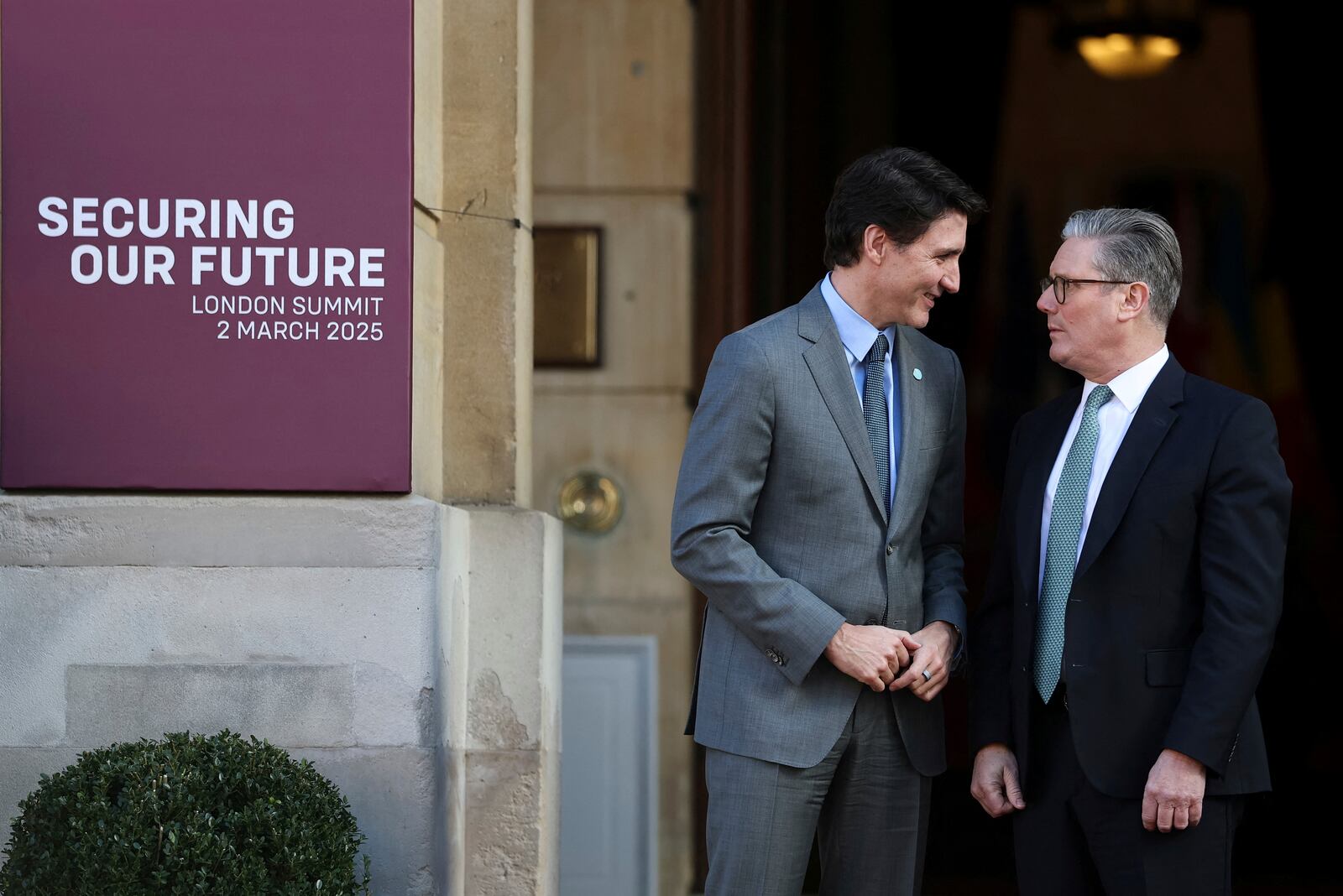 Britain's Prime Minister Keir Starmer, right, welcomes Canadian Prime Minister Justin Trudeau to the European leaders' summit to discuss Ukraine, at Lancaster House, London, Sunday March 2, 2025. (Toby Melville/Pool via AP)