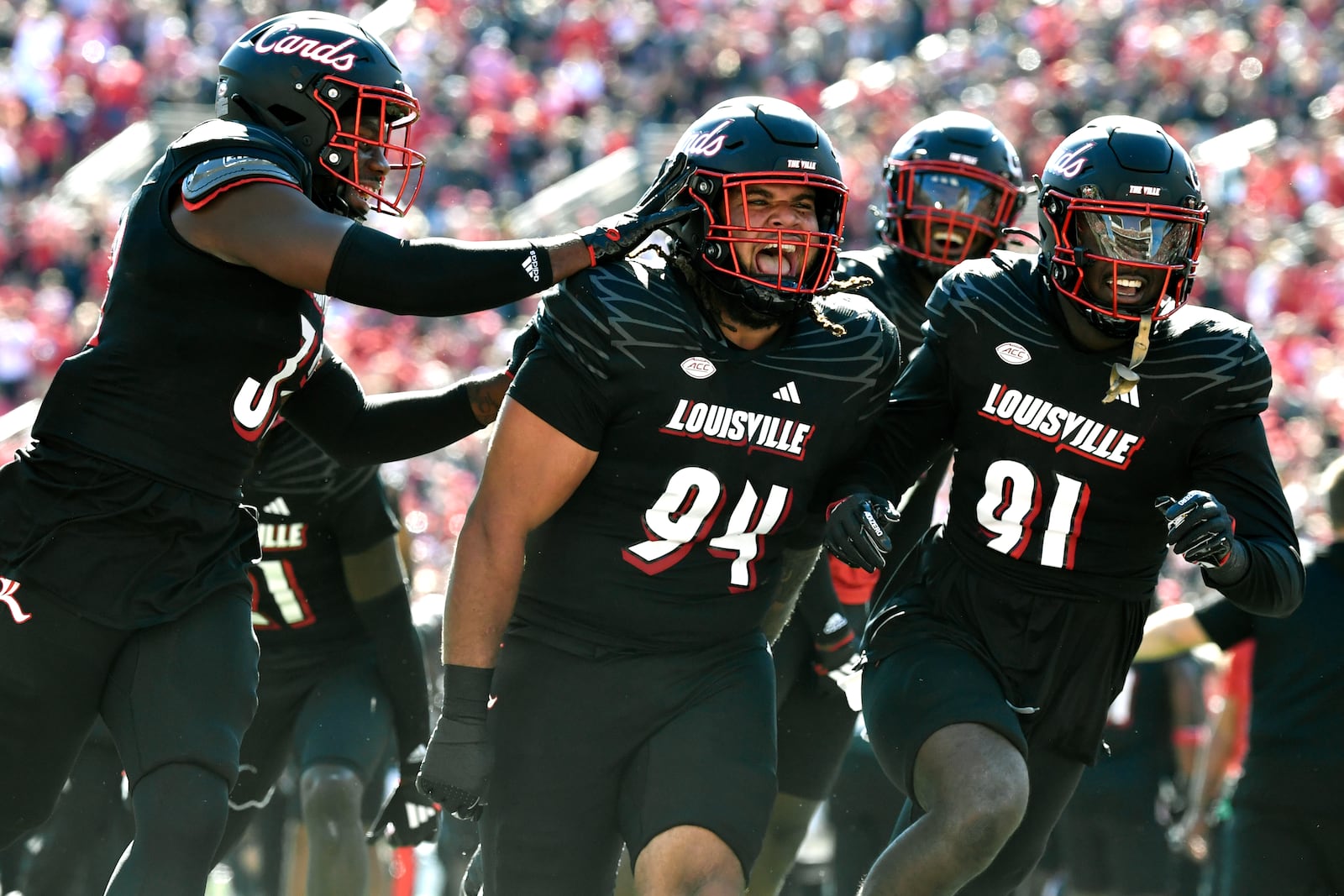 Louisville defensive lineman Jordan Guerad (94) celebrates with teammates linebacker Jurriente Davis (32), left, and defensive lineman Richard Kinley (91) after recovering a fumble during the second half of an NCAA college football game against Miami in Louisville, Ky., Saturday, Oct. 19, 2024. Miami won 52-45. (AP Photo/Timothy D. Easley)