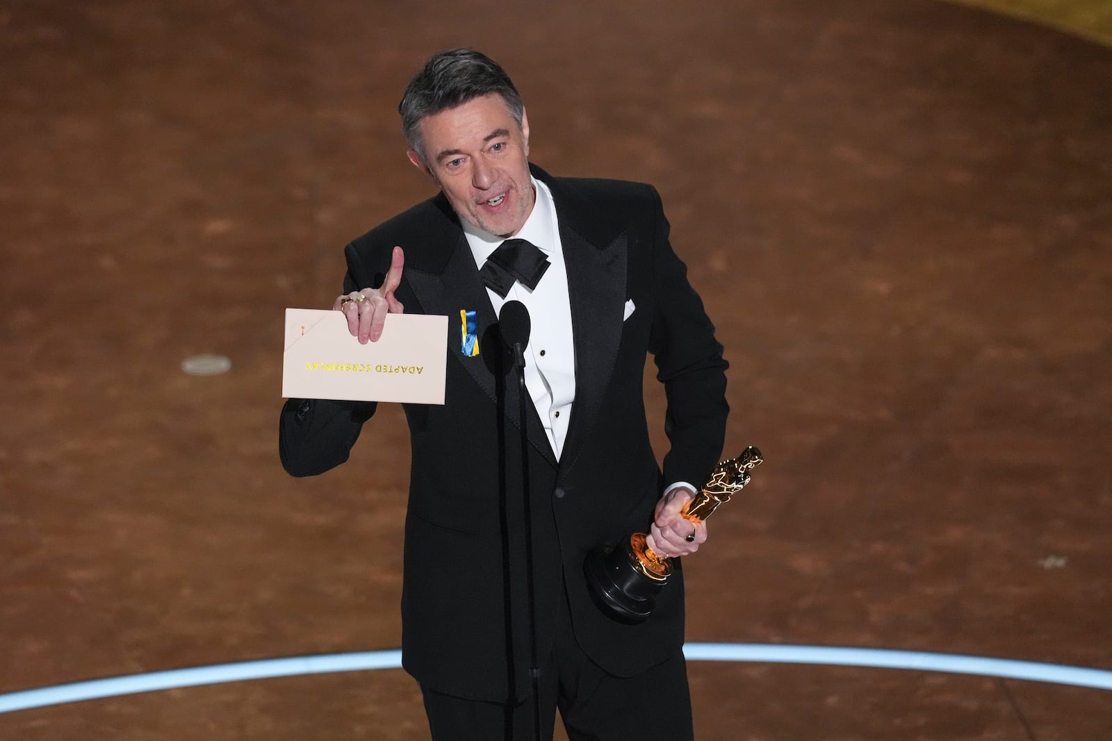 Peter Straughan accepts the award for best adapted screenplay for "Conclave" during the Oscars on Sunday, March 2, 2025, at the Dolby Theatre in Los Angeles. (AP Photo/Chris Pizzello)