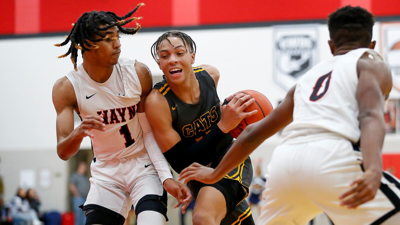 Springfield High School sophomore Aaron Scott drives through Wayne's Lawrent Rice (left) and RJ Mukes (right) during a game on Tuesday night in Huber Heights. The Warriors won 82-65. CONTRIBUTED PHOTO BY MICHAEL COOPER