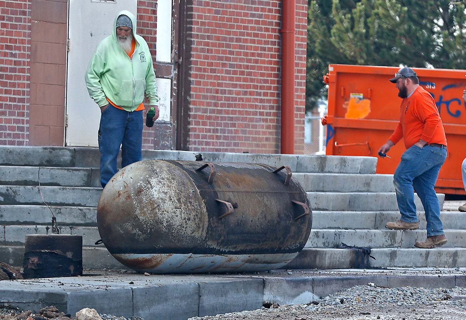 Construction workers look over the propane tank that exploded Tuesday, March 21, 2023 at the former Children's Home on Home Road. Three construction workers were injured in the blast, two suffered severe burns and were transported by medical helicopter. The explosion also damaged several cars and the building next door that houses the Neighborhood Housing Partnership of Greater Springfield. Home Road was block in both directions for nearly two hours. BILL LACKEY/STAFF