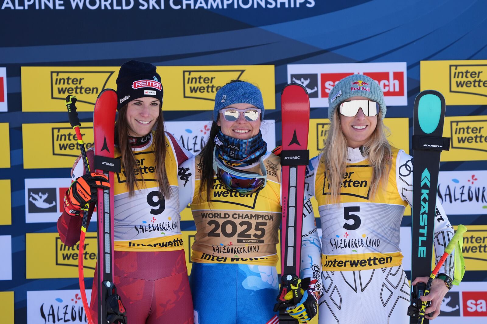 United States' Breezy Johnson, center, winner of a gold medal in a women's downhill race, celebrates on the podium with silver medalist Austria's Mirjam Puchner, left, and bronze medalist Czech Republic's Ester Ledecka, at the Alpine Ski World Championships, in Saalbach-Hinterglemm, Austria, Saturday, Feb. 8, 2025. (AP Photo/Giovanni Auletta)