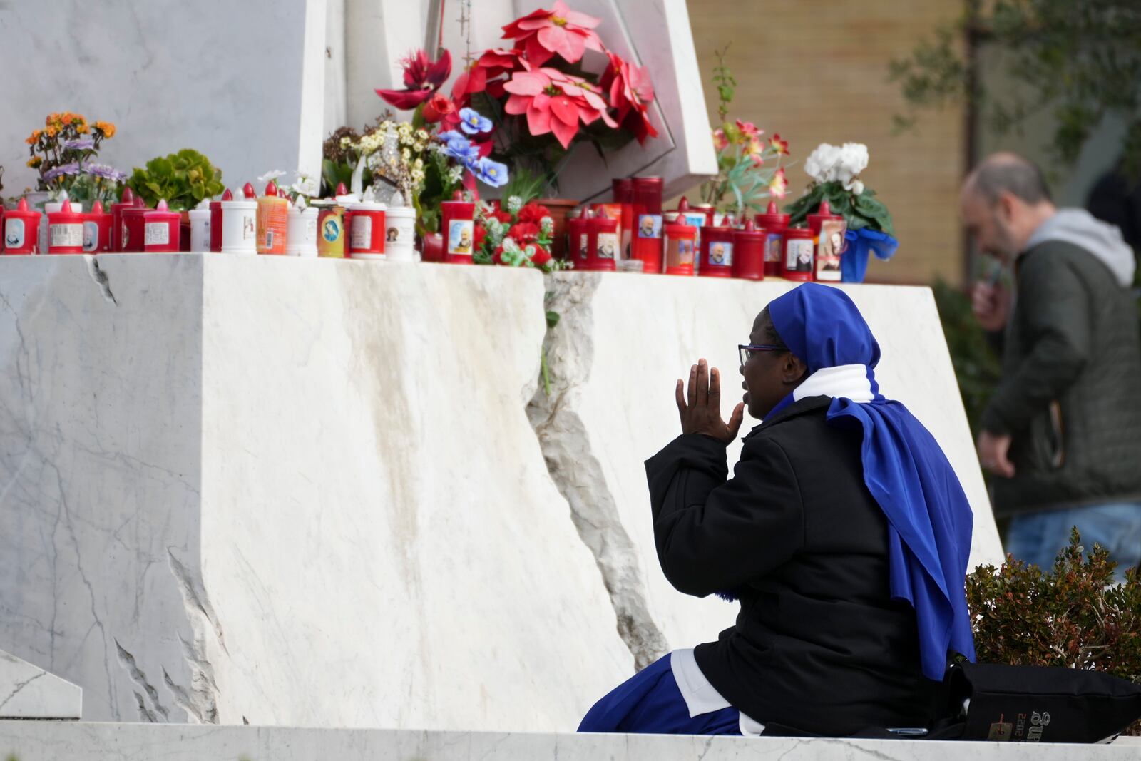 A nun sits in front of the main entrance of the Agostino Gemelli Polyclinic, in Rome, Monday, Feb. 17, 2025, where Pope Francis has been hospitalized to undergo some necessary diagnostic tests and to continue his ongoing treatment for bronchitis. (AP Photo/Andrew Medichini)