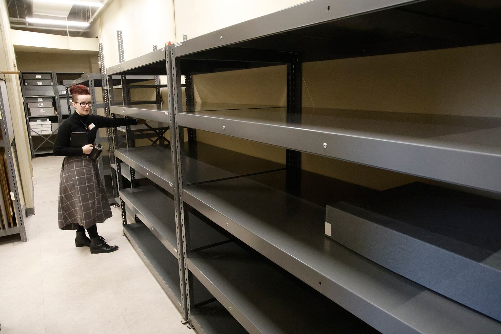 Miranda Taylor, Collections Assistant at the Clark County Historical Society, talks about the new larger shelving that the Society purchased with grant money Thursday, Dec. 28, 2023. The Historical Society will be closed along with the museum in January to update some exhibits and organizing the collections on the new shelves. BILL LACKEY/STAFF