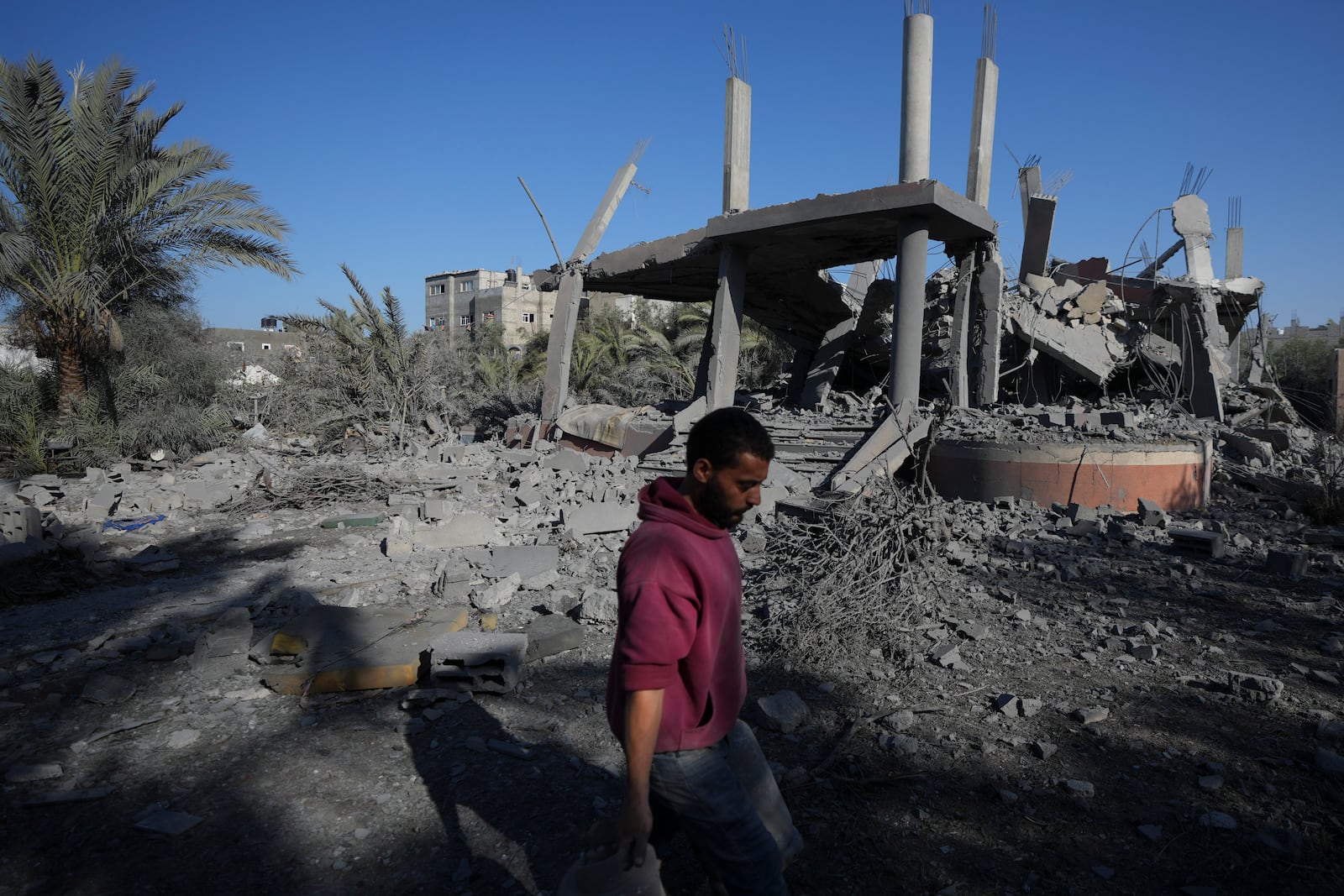 A Palestinian walks past a destroyed building following an overnight Israeli strike in Deir al-Balah, Gaza Strip, Wednesday, Dec. 4, 2024. (AP Photo/Abdel Kareem Hana)