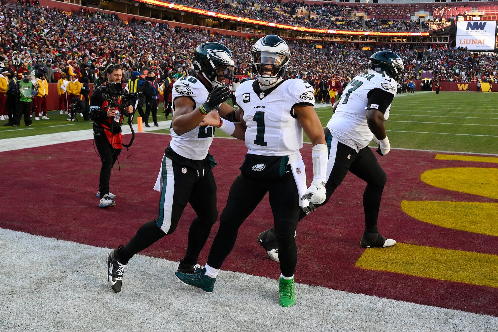 Philadelphia Eagles running back Saquon Barkley (26) celebrating his touchdown with teammate Philadelphia Eagles quarterback Jalen Hurts (1) during the first half of an NFL football game against the Washington Commanders, Sunday, Dec. 22, 2024, in Landover, Md. (AP Photo/Nick Wass)