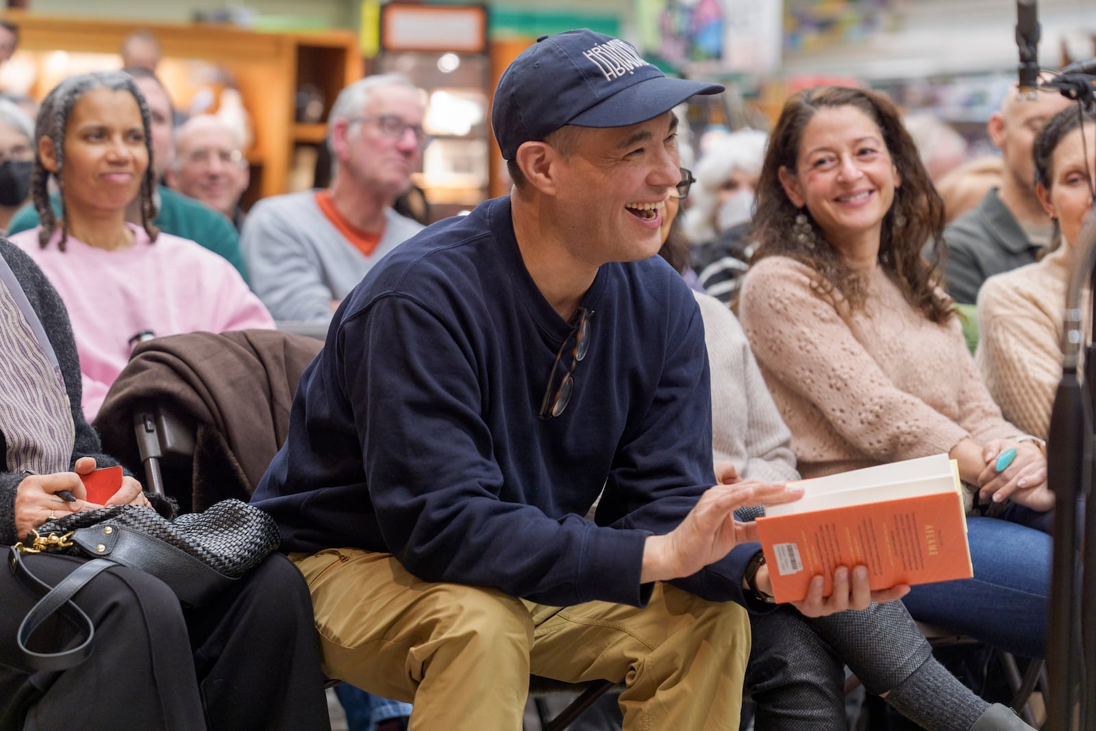 Jeremy Hunter, Founder of the Executive Mind Leadership Institute, who lost his Holmes House in the Eaton Fire, smiles as he listens to author Pico Iyer present his book "Aflame: Learning from Silence" at Vroman's bookstore in Pasadena, Calif., on Tuesday, Jan. 28, 2025. (AP Photo/Damian Dovarganes)