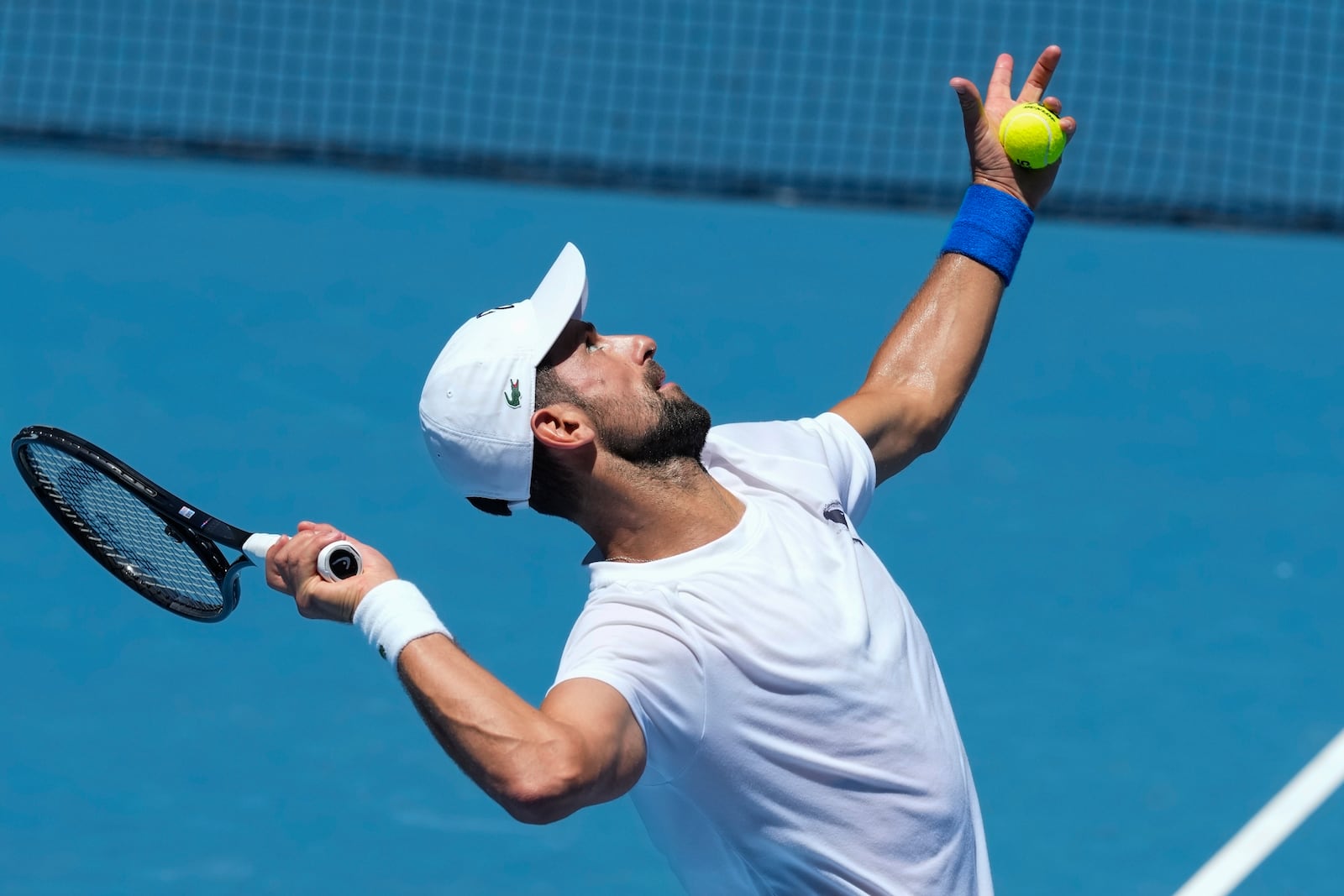 Serbia's Novak Djokovic serves during a practice session ahead of the Australian Open tennis championship in Melbourne, Australia, Saturday, Jan. 11, 2025. (AP Photo/Manish Swarup)