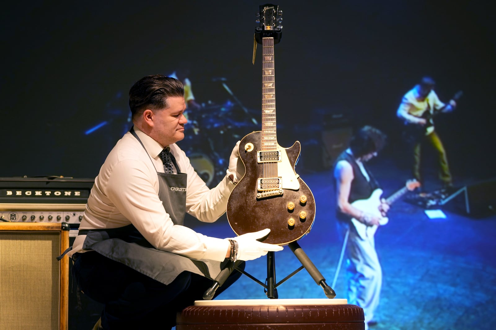 An art handler displays a Gibson, Kalamazoo, Michigan, 1954 and 1972 A Solid-Body Electric Guitar, Les Paul, known as "The Oxblood," at the Jeff Beck The Guitar Collection in London, Tuesday, Jan. 14, 2025, ahead of the pre-sale exhibition at Christies auction rooms in London. (AP Photo/Kirsty Wigglesworth)