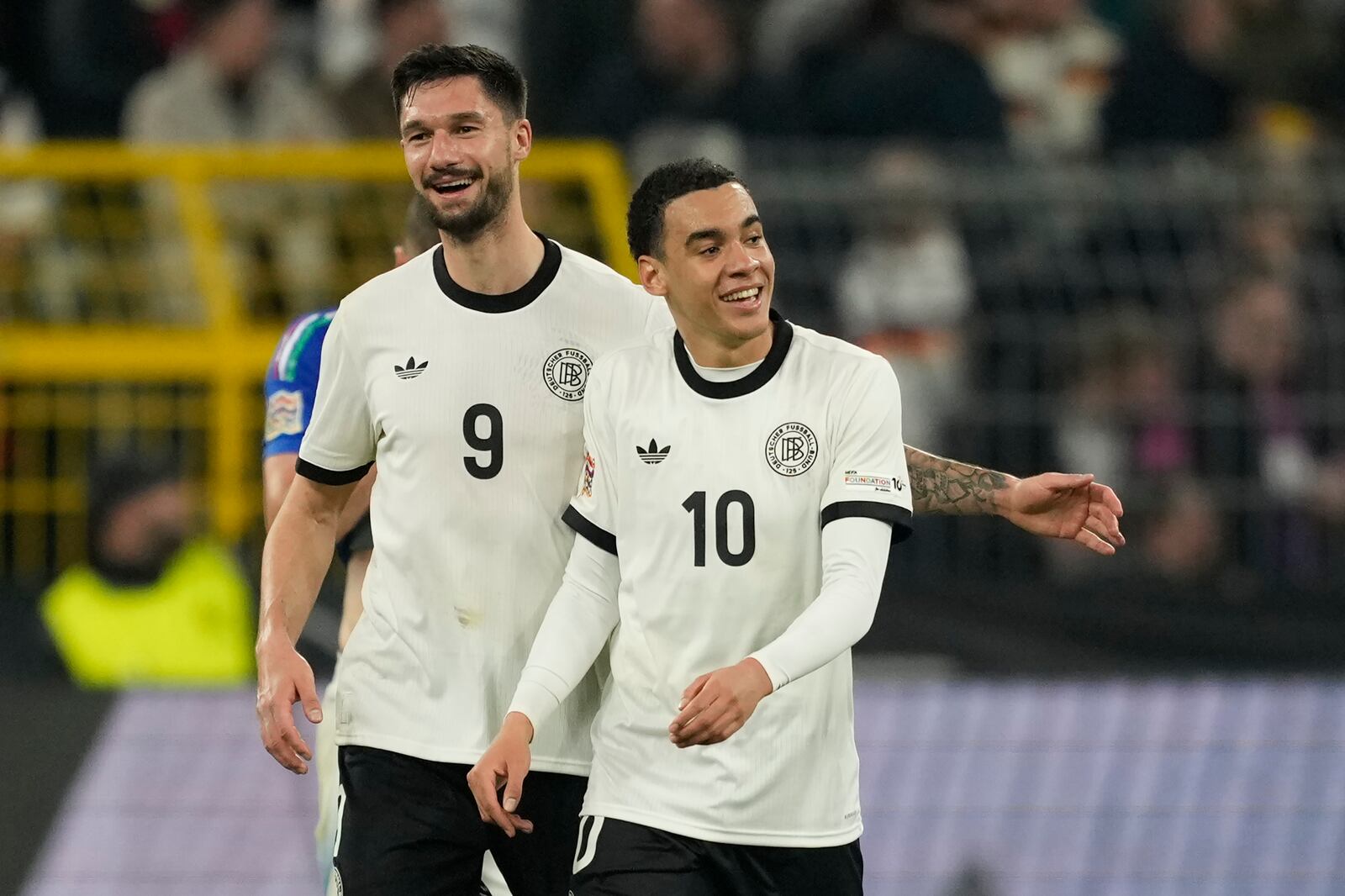 Germany's Jamal Musiala, right, celebrates after scoring his side's second goal with Tim Kleindienst during the Nations League quarterfinal second leg soccer match between Germany and Italy at the Signal-Iduna Park in Dortmund, Germany, Sunday, March 23, 2025. (AP Photo/Martin Meissner)