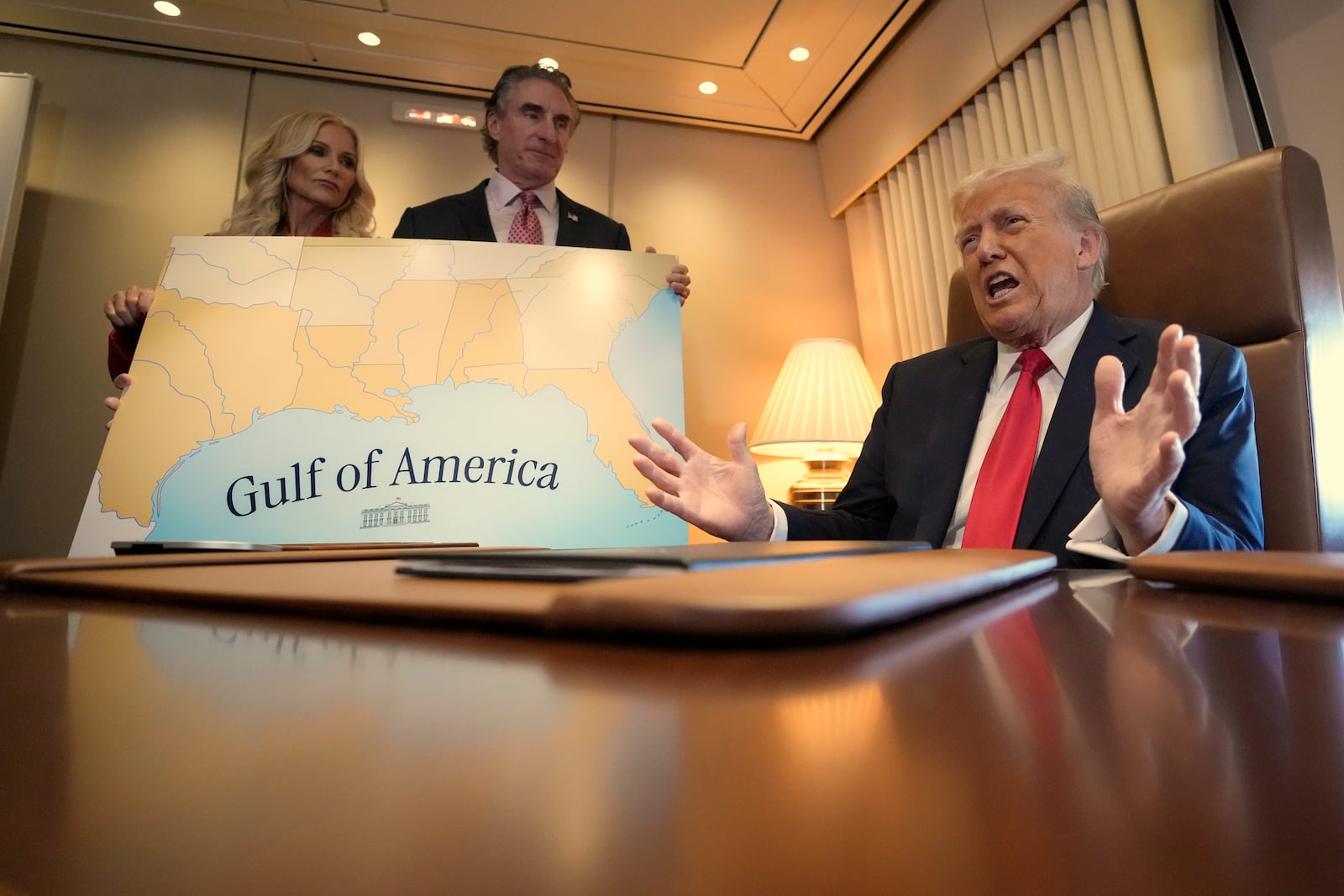 President Donald Trump, from right, speaks to reporters accompanied by Interior Secretary Doug Burgum and Burgum's wife Kathryn Burgum, aboard Air Force One where Trump signed a proclamation declaring Feb. 9 Gulf of America Day, as he travels from West Palm Beach, Fla. to New Orleans, Sunday, Feb. 9, 2025. (AP Photo/Ben Curtis)