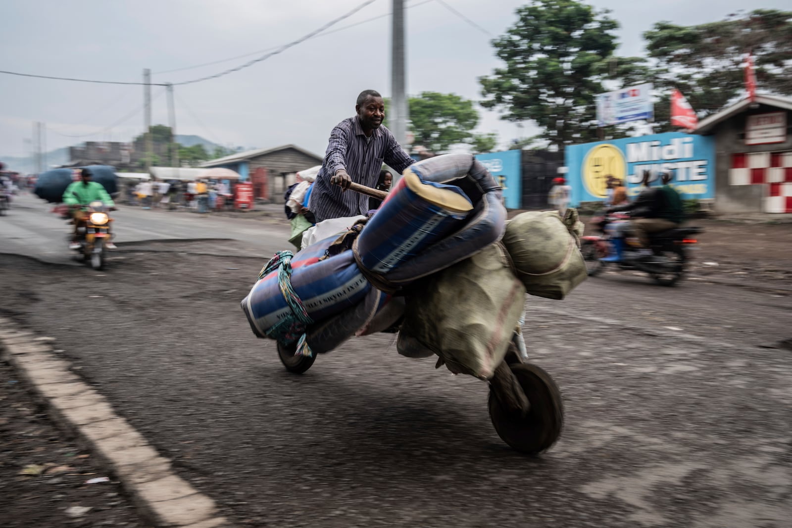 People displaced by the fighting with M23 rebels make their way to the center of Goma, Democratic Republic of the Congo, Sunday, Jan. 26, 2025. (AP Photo/Moses Sawasawa)