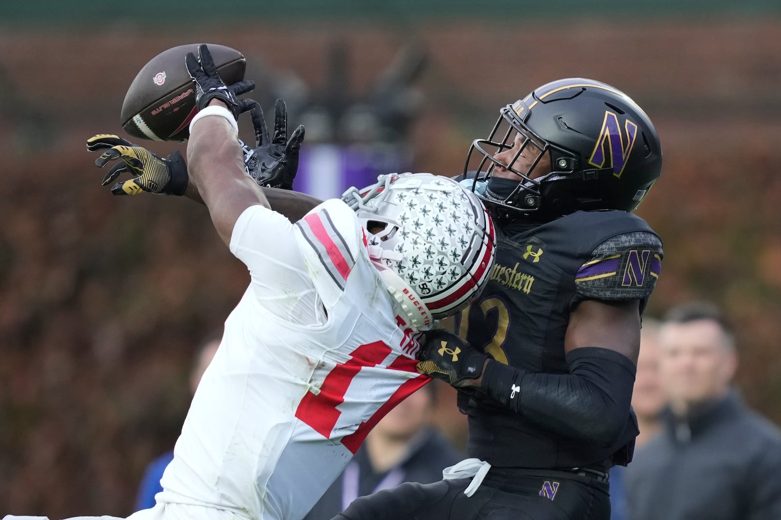 Northwestern defensive back Josh Fussell (13) breaks up a pass intended for Ohio State wide receiver Carnell Tate during the second half of an NCAA college football game at Wrigley Field on Saturday, Nov. 16, 2024, in Chicago. (AP Photo/Charles Rex Arbogast)