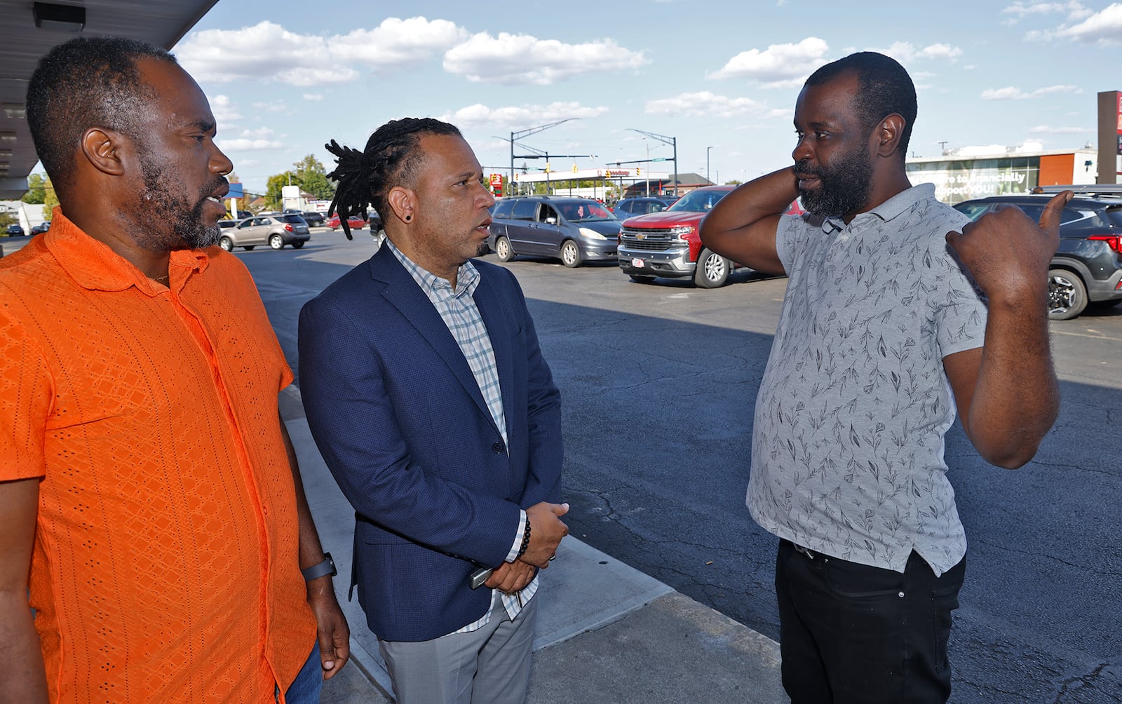 Dady Fanfan, a Haitian real estate agent who came to Springfield in 2020, right, talks with fellow Haitian business men Jacob Paven, center, and Lukens Merzius Thursday, Sept. 19, 2024 in the Southgate Shopping Center. BILL LACKEY/STAFF