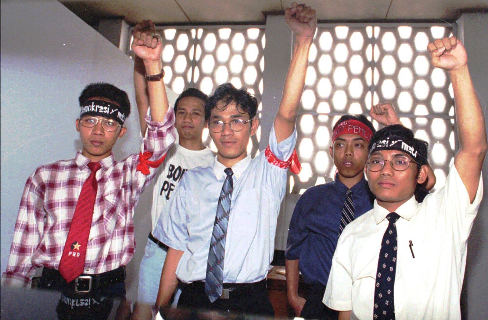 FILE - Five activists of the unrecognized People's Democratic Party, including Budiman Sudjatmiko, center, raise their fists while posing for photographers in front of a room at the Central Jakarta district court Monday, April 28, 1997. (AP Photo/Ujang, File)