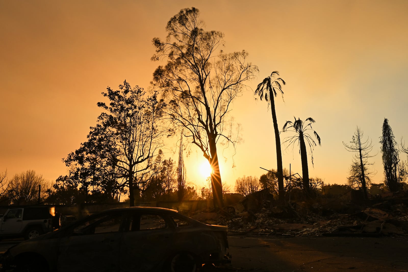 The sun sets over damage from the Eaton Fire, Thursday, Jan. 9, 2025, in Altadena, Calif. (AP Photo/Nic Coury)