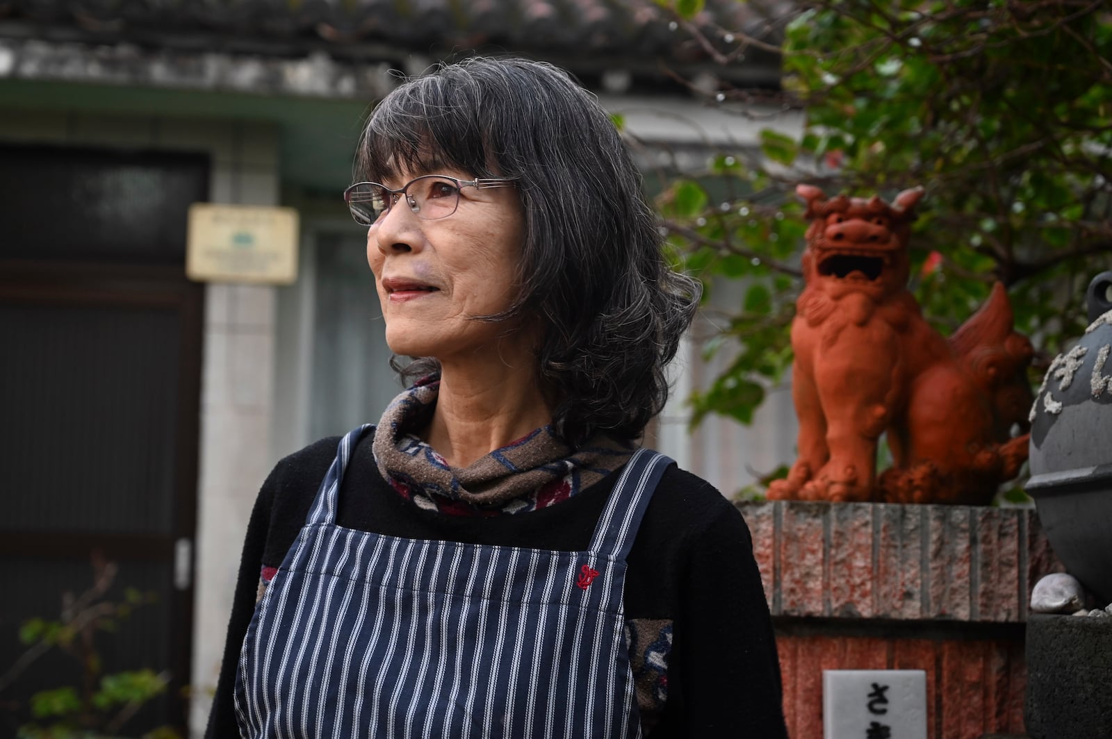 Fumie Kano, who opposes the presence of the Japan Self-Defense Forces (JSDF) base on Yonaguni island, poses for photo in front of her inn on Yonaguni, a tiny island on Japan’s western frontier, Friday, Feb. 14, 2025. (AP Photo/Ayaka McGill)