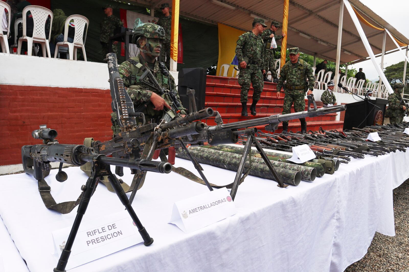 Soldiers guard weapons the military says was turned over by members of holdouts from the demobilized Revolutionary Armed Forces of Colombia (FARC), who retreated to the Army after being driven out of the Catatumbo region by National Liberation Army (ELN) rebels, in Cúcuta, Colombia, Saturday, Jan. 25, 2025.(AP Photo/Mario Caicedo)