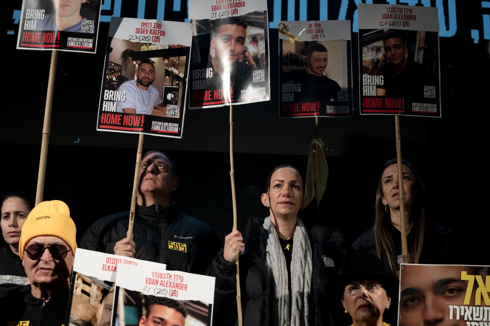 Yael Alexander, center in grey scarf, holds a poster of her son, Edan, who was taken hostage by Hamas militants on Oct. 7, 2023, during a weekly rally for families of hostages held in the Gaza Strip and their supporters, in Tel Aviv, Israel, Saturday, Feb. 22, 2025. (AP Photo/Maya Alleruzzo)