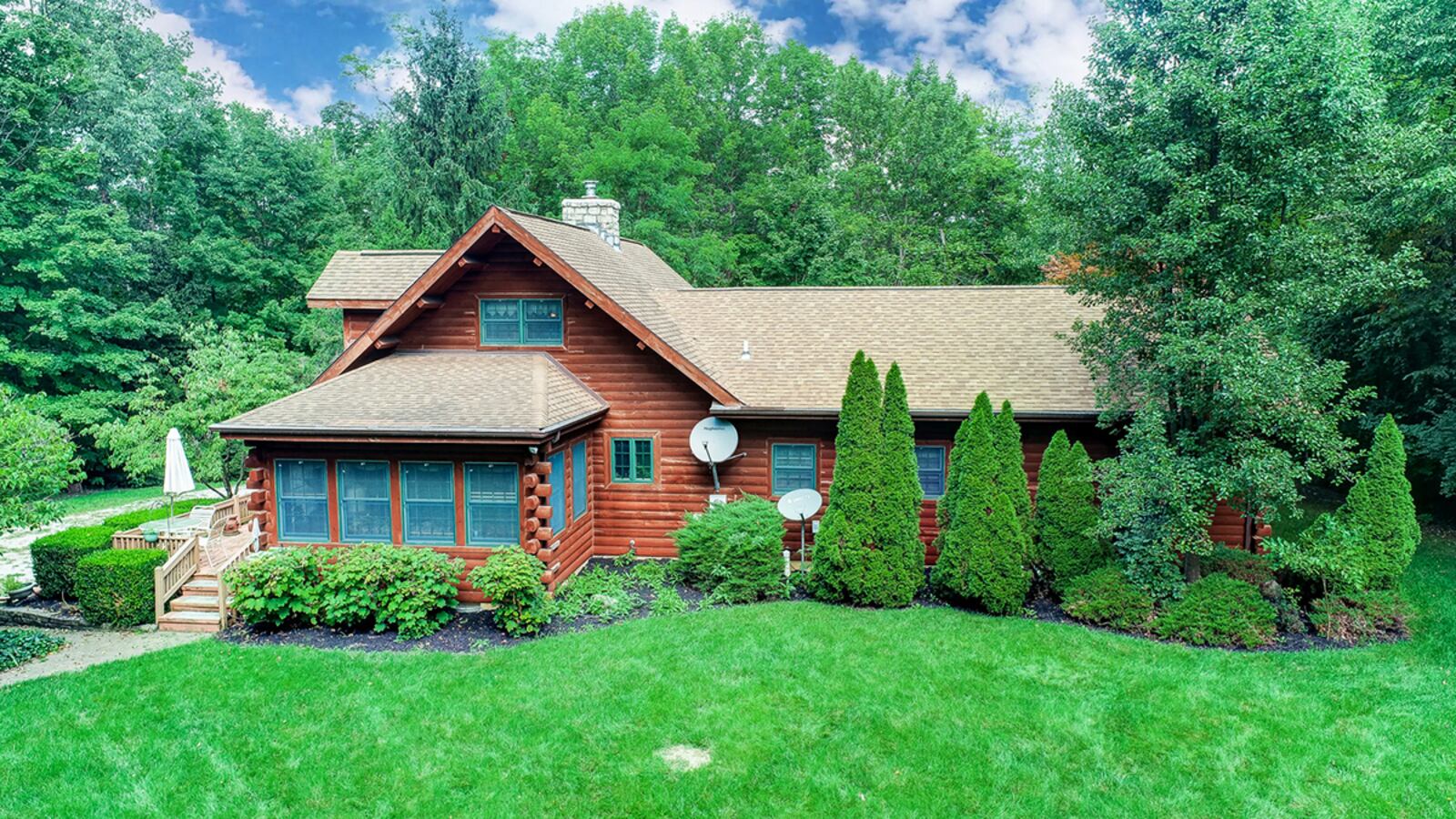 The rear of the home has a sunroom with exterior door leading to the side wood deck. A large open back yard area with lawn extends to the woods. CONTRIBUTED PHOTO