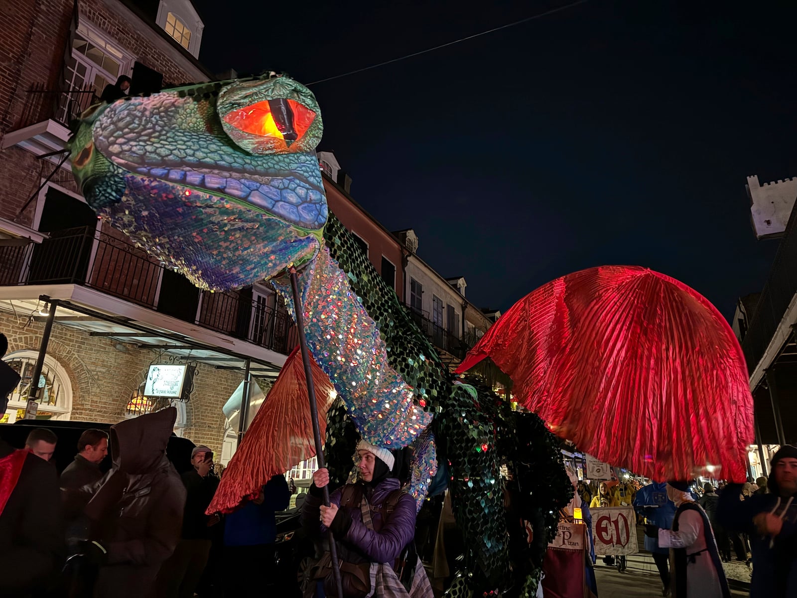 Volunteers carry a makeshift dragon through the streets of New Orleans famed French Quarter for the Joan of Arc parade kicking off the start of the city's carnival season Monday, Jan. 6, 2025. (AP Photo/Jack Brook)