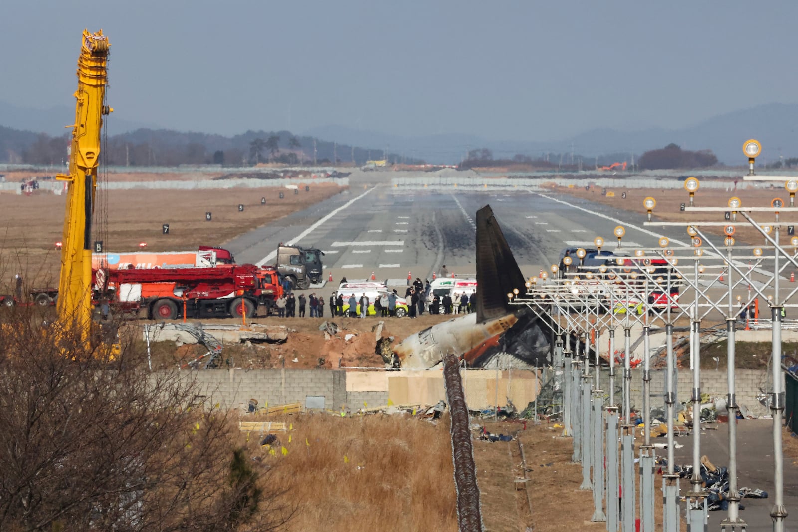 Relatives of passengers on a plane which skidded off a runway and burst into flames, are seen near the site of a plane crash at Muan International Airport in Muan, South Korea, Wednesday, Jan. 1, 2025. (Lee Jin-wook/Yonhap via AP)