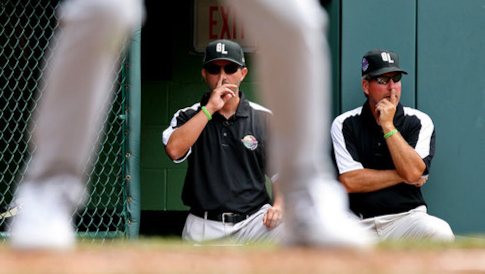 Coach Ken Coomer, left, gives signs to his catcher Sam Scott next to Coach Tim Nichting during a game against Toms River, N.J., at Howard J. Lamade Stadium in South Williamsport, Pa., in 2010.