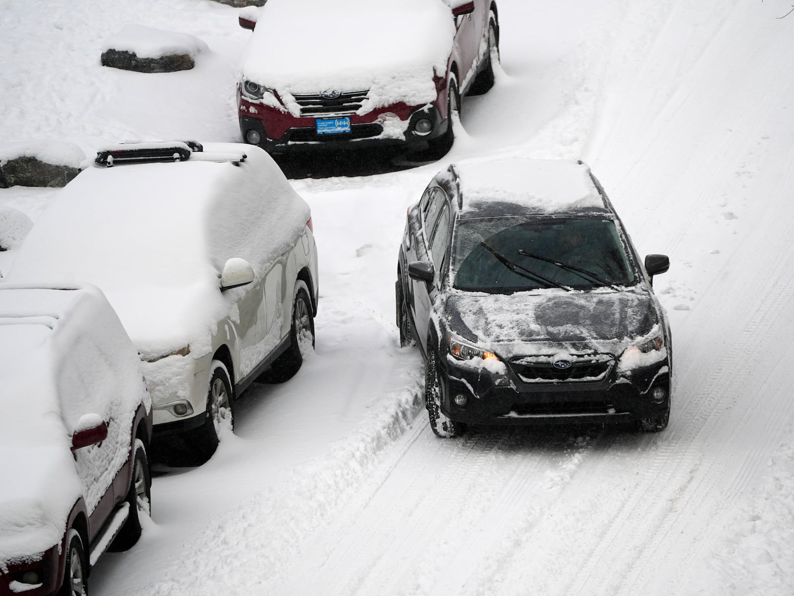 A motorist struggles to move along Pearl Street as a winter storm sweeps over the intermountain West, plunging temperatures into the single digits and bringing along a light snow in its wake Saturday, Jan. 18, 2025, in Denver. (AP Photo/David Zalubowski)