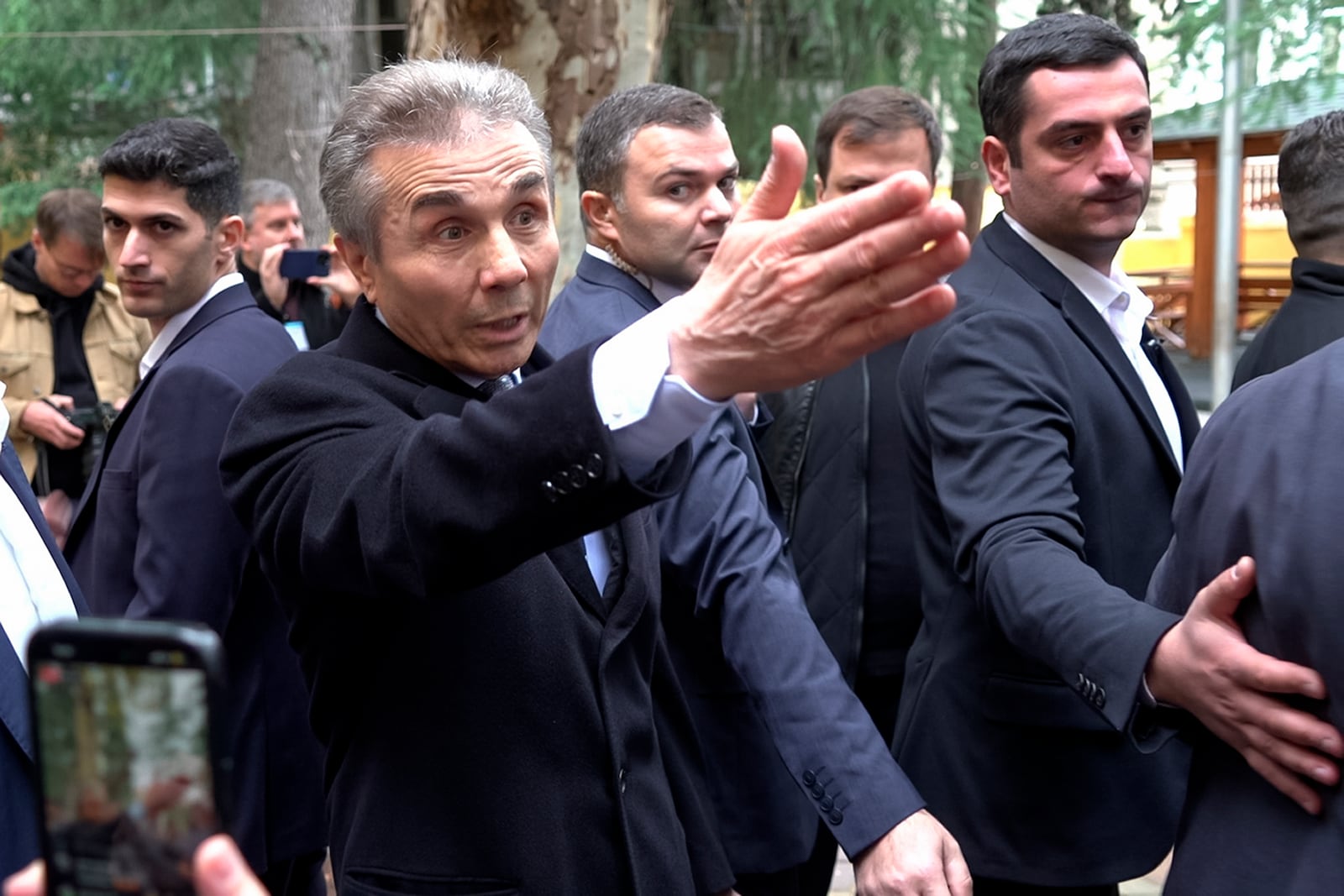 In this photo taken from video, Bidzina Ivanishvili, leader of the created by him the Georgian Dream, center, gestures as he arrives to vote at a polling station during the parliamentary election in Tbilisi, Georgia, Saturday, Oct. 26, 2024. (AP Photo/Kostya Manenkov)