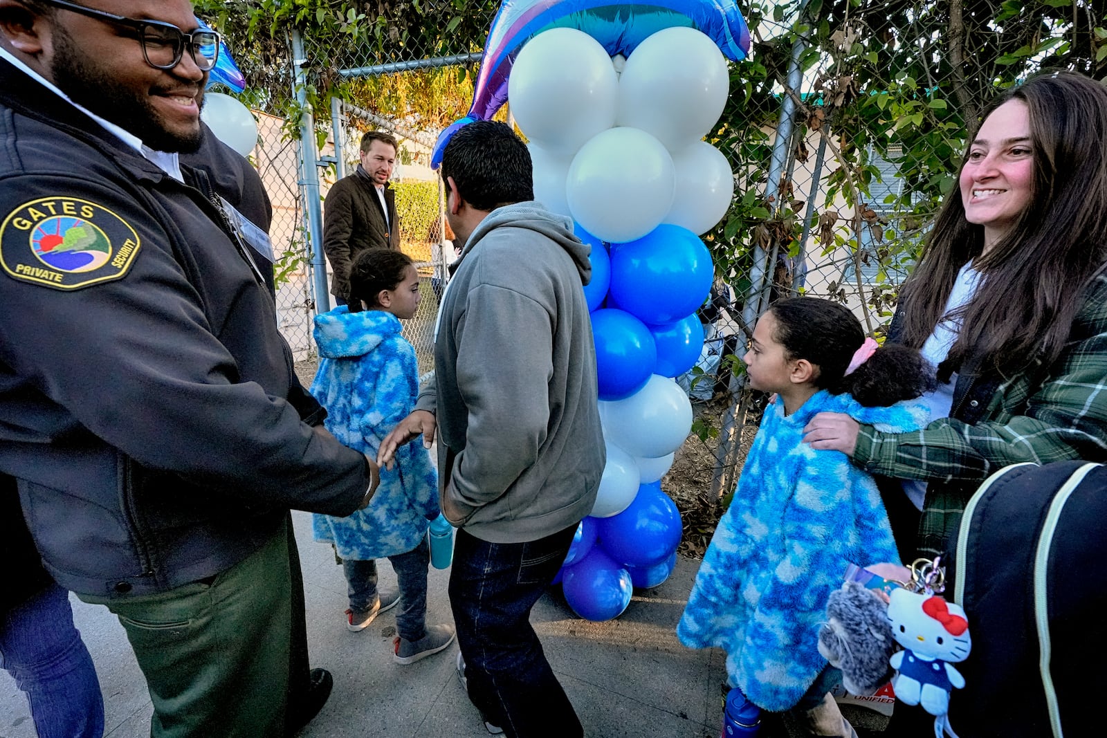 Palisades Charter Elementary School students and their parents arrive at their new school, the Brentwood Elementary Science Magnet school in the Brentwood section of Los Angeles on Wednesday, Jan. 15, 2025. (AP Photo/Richard Vogel)