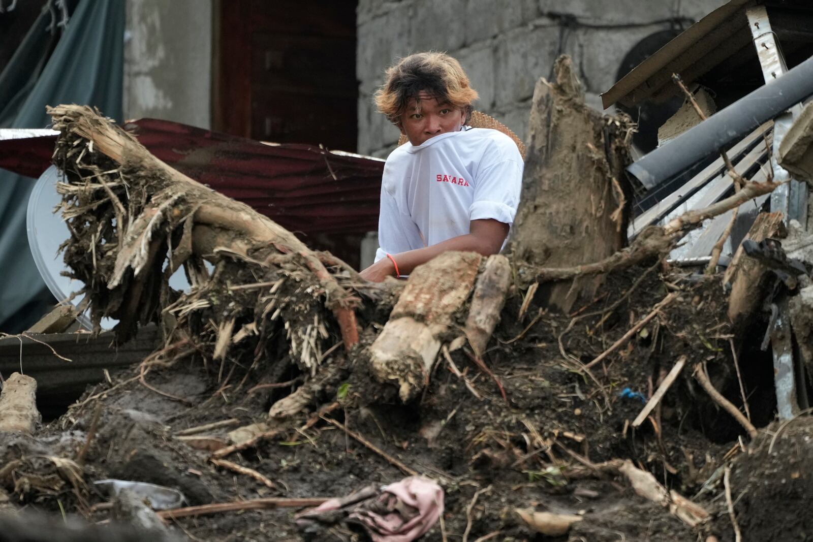 A villager watches rescue operations after a recent landslide triggered by Tropical Storm Trami struck Talisay, Batangas province, Philippines leaving thousands homeless and several villagers dead on Saturday, Oct. 26, 2024. (AP Photo/Aaron Favila)