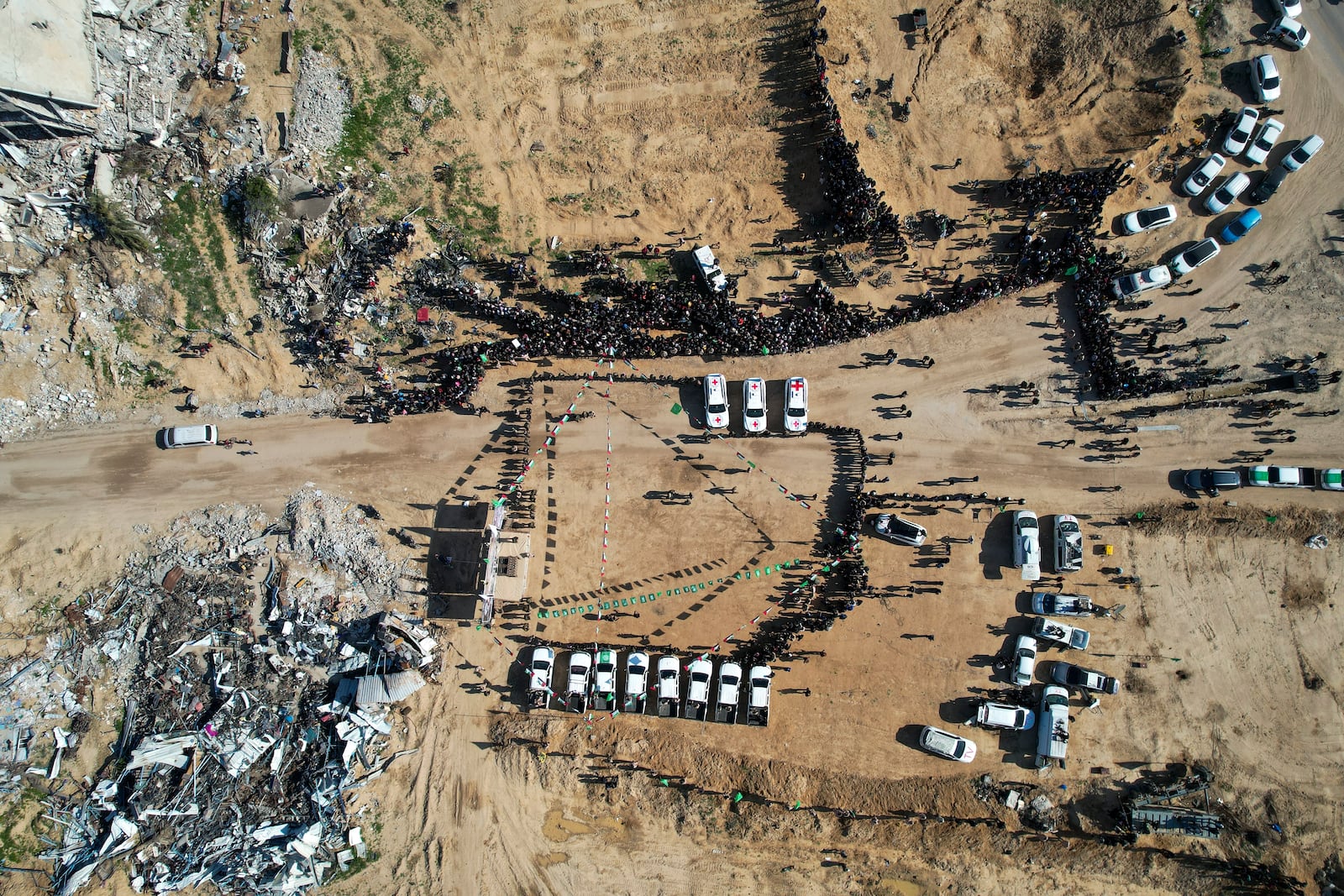 Red Cross cars and Palestinian public wait for the hand over of hostages Iair Horn, Sagui Dekel Chen, and Alexander Troufanov, to the Red Cross by Hamas and islamic Jihad fighters in Khan Younis, Gaza Strip, Saturday, Feb. 15, 2025. (AP Photo/Mohammad Abu Samra)