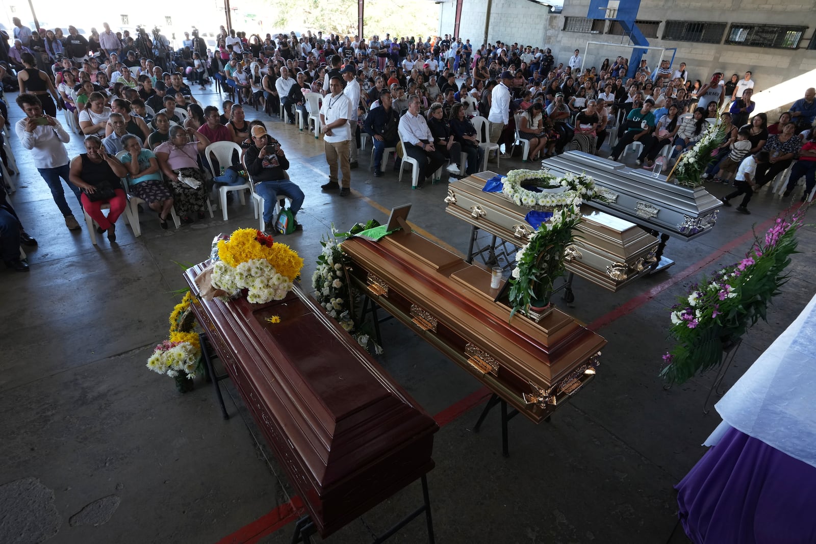 Mourners attend a funeral service for the victims of a bus crash, in Santo Domingo Los Ocotes, Guatemala, Tuesday, Feb. 11, 2025. Dozens of passengers died after their bus plunged into a gorge and landed under a bridge on Feb. 10 on the outskirts of the Guatemalan capital. (AP Photo/Moises Castillo)