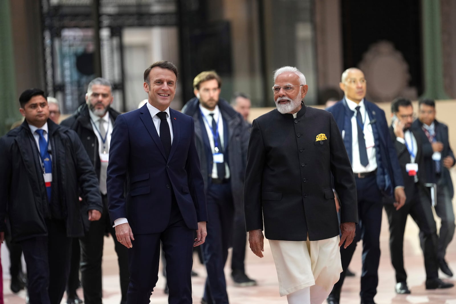 French President Emmanuel Macron, center left, walks with India's Prime Minister Narendra Modi at the Grand Palais during the Artificial Intelligence Action Summit in Paris, Tuesday, Feb. 11, 2025. (AP Photo/Aurelien Morissard)