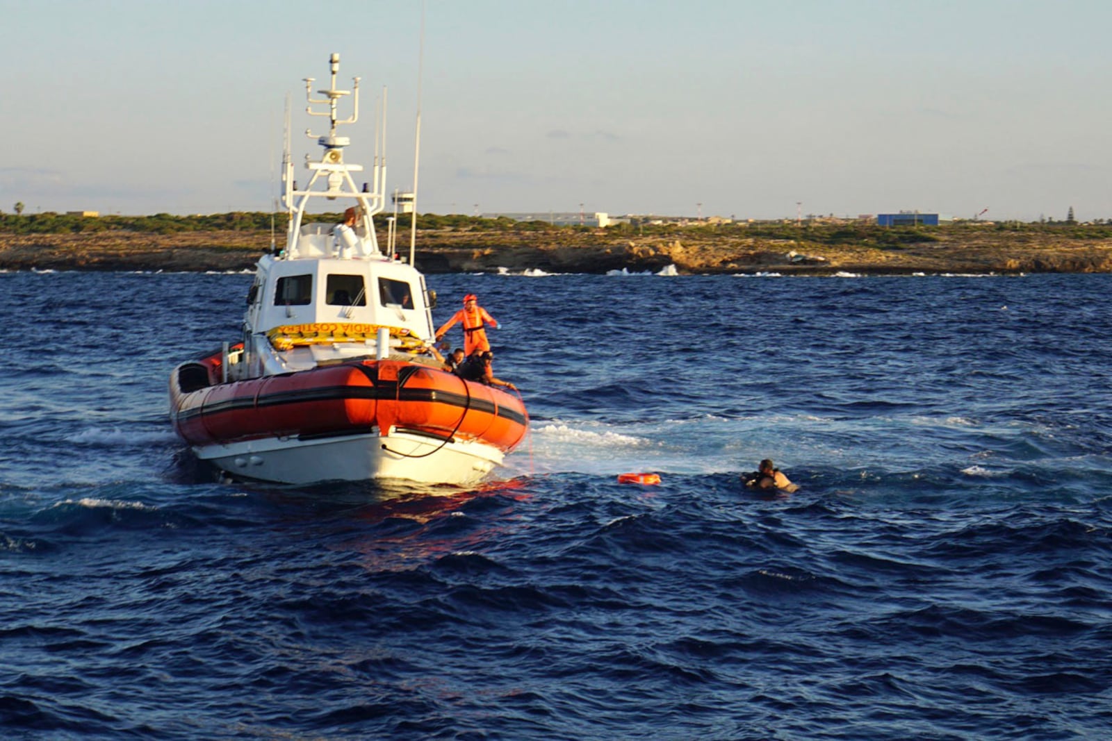 FILE - A man who threw himself in the water from the Open Arms vessel, is intercepted by the Italian Coast guards as he tried to swim to the island of Lampedusa, southern Italy, Tuesday, Aug. 20, 2019. (AP Photo/Francisco Gentico, File)