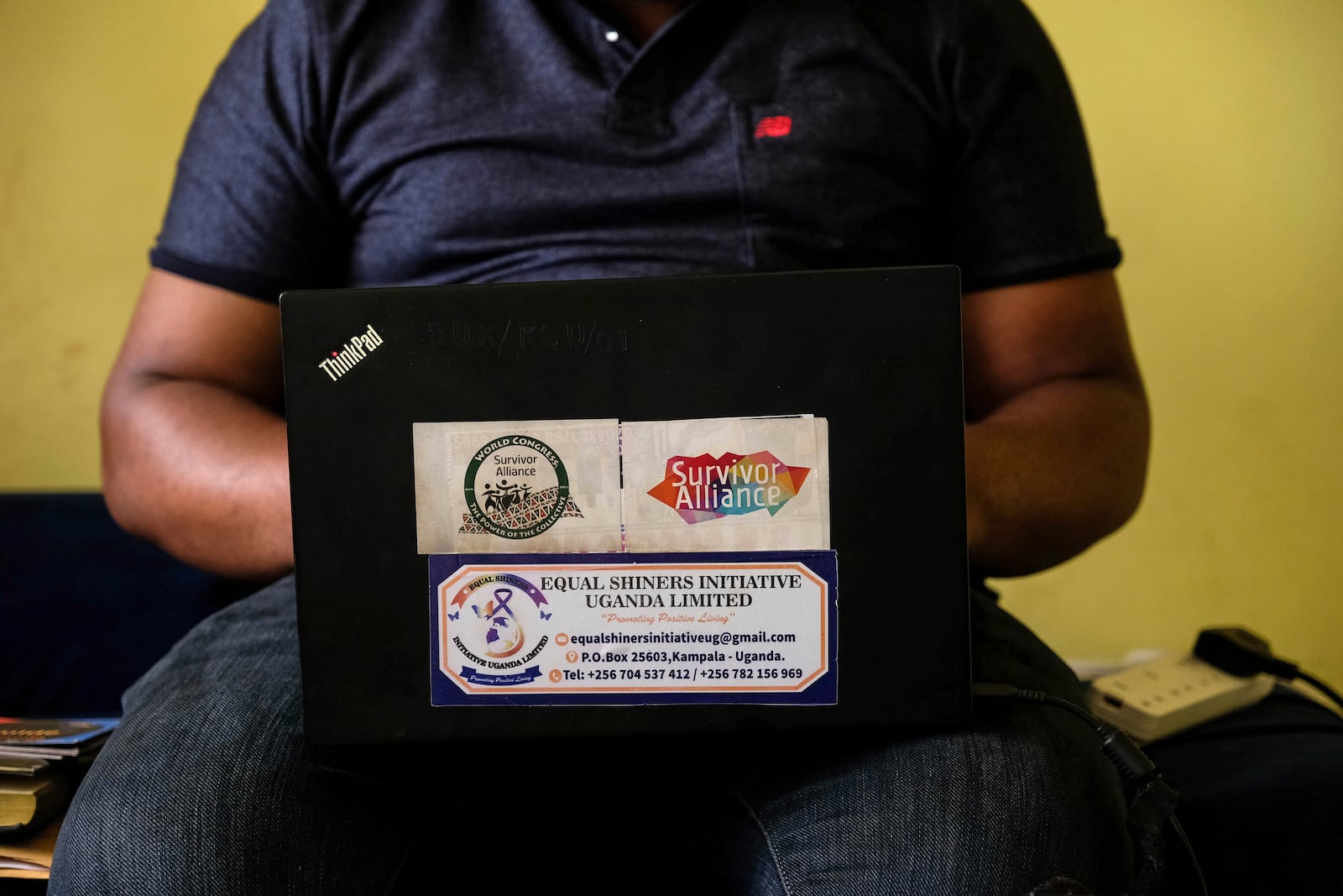 Ugandan human rights activist Kennedy Pius reads a letter from USAID on a laptop at home in Kampala, Uganda, Jan. 28, 2025. (AP Photo/Hajarah Nalwadda)