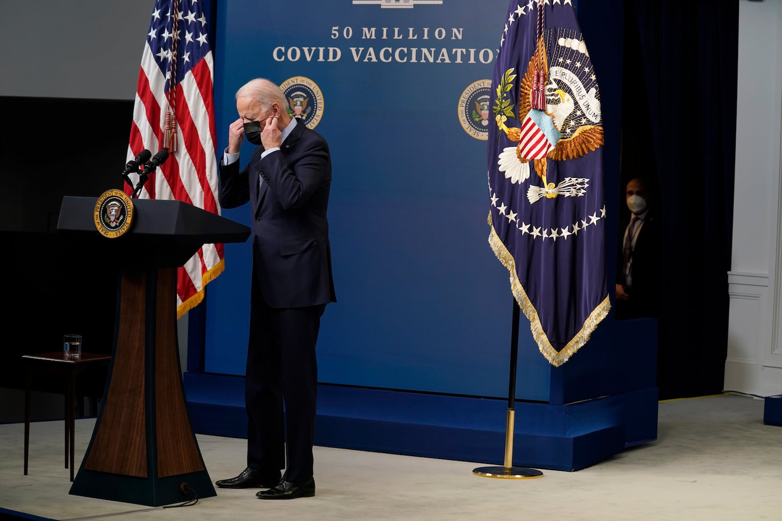 FILE - President Joe Biden puts on his face mask after speaking during an event to commemorate the 50 millionth COVID-19 shot, in the South Court Auditorium on the White House campus, Feb. 25, 2021, in Washington. (AP Photo/Evan Vucci, File)