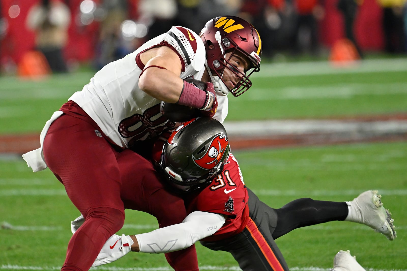 Washington Commanders tight end Zach Ertz, top, catches a pass against Tampa Bay Buccaneers safety Antoine Winfield Jr. (31) during the first half of an NFL wild-card playoff football game in Tampa, Fla., Sunday, Jan. 12, 2025. (AP Photo/Jason Behnken)