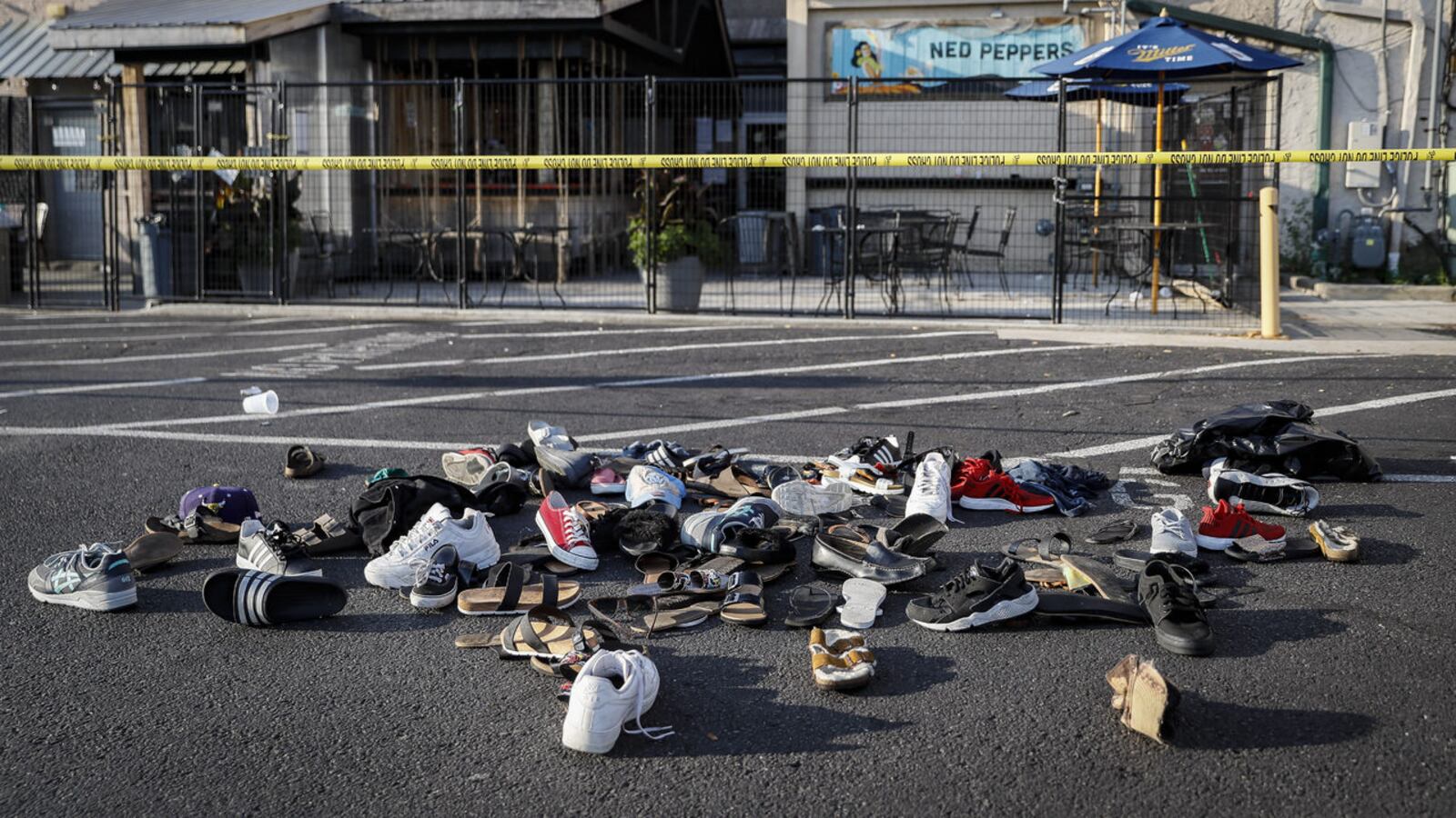 Shoes are piled outside the scene of a mass shooting in Dayton, Ohio, in the city's Oregon District Sunday, Aug. 4, 2019. Nine people were killed and more than two dozen injured in the attack early Sunday by an alleged 24-year-old man.