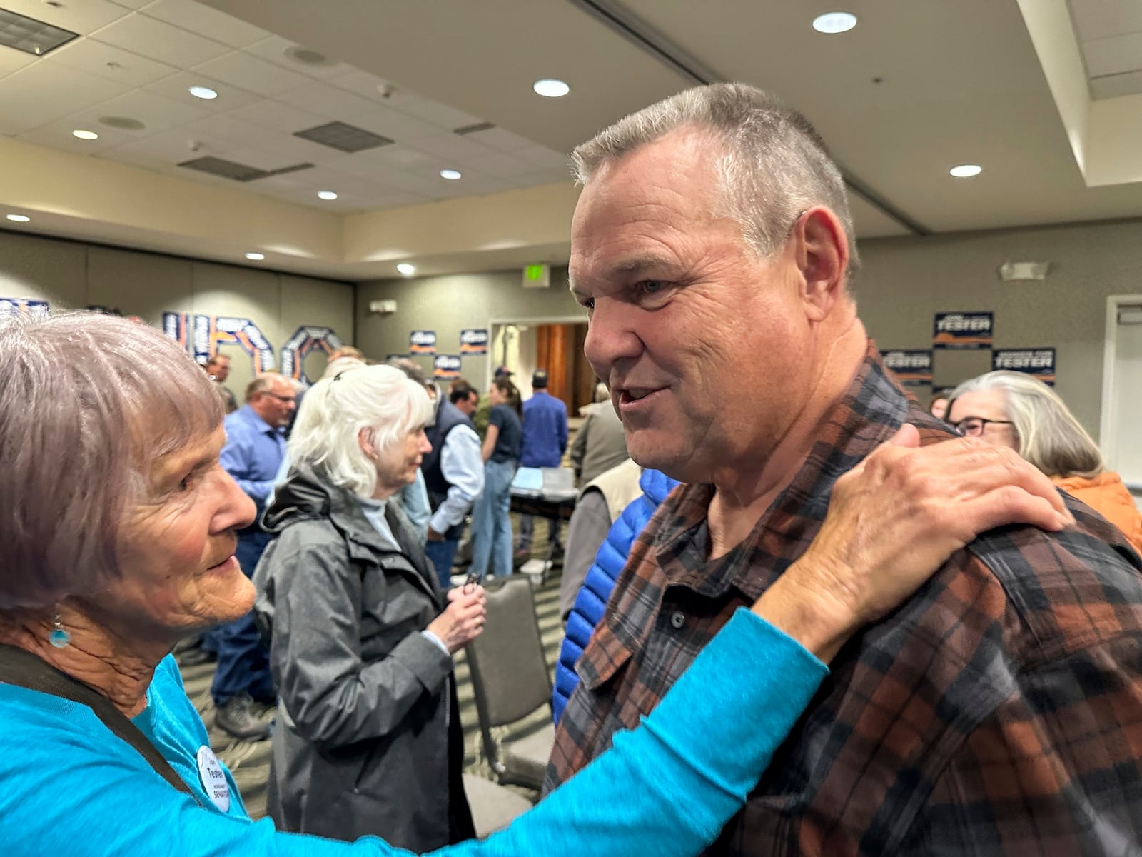 Sen. Jon Tester, a Democrat from Montana seeking re-election to a fourth term, speaks with a supporter during campaign rally in a hotel ballroom, Oct. 25, 2024, in Bozeman, Mont. (AP Photo/Matthew Brown)