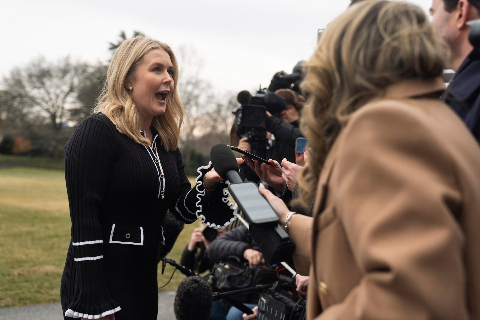 White House press secretary Karoline Leavitt, left, speaks to reporters as she arrives with President Donald Trump on the South Lawn at the White House, Saturday, Feb. 22, 2025, in Washington. (AP Photo/Manuel Balce Ceneta)